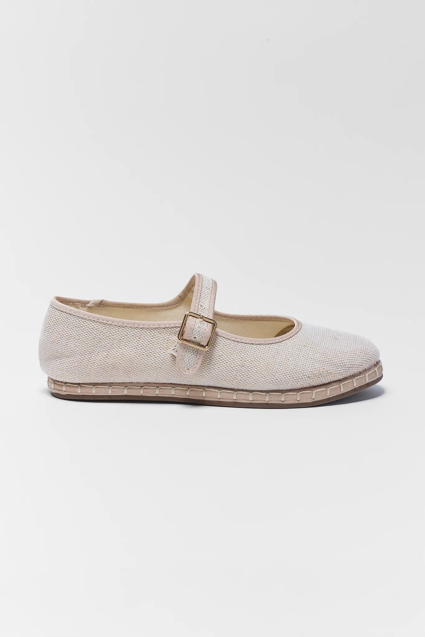 Beige flat shoe with a strap on a white background