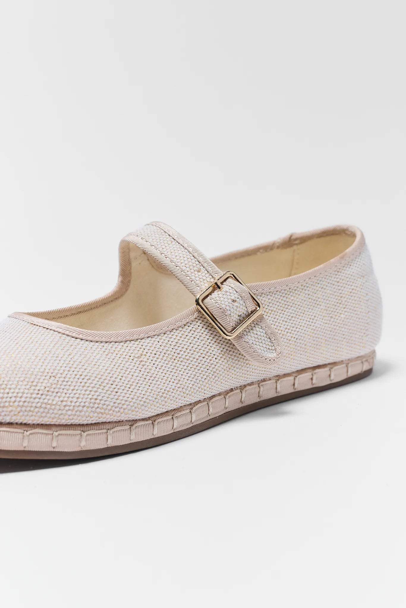 Beige flat shoe with a buckle on a white background