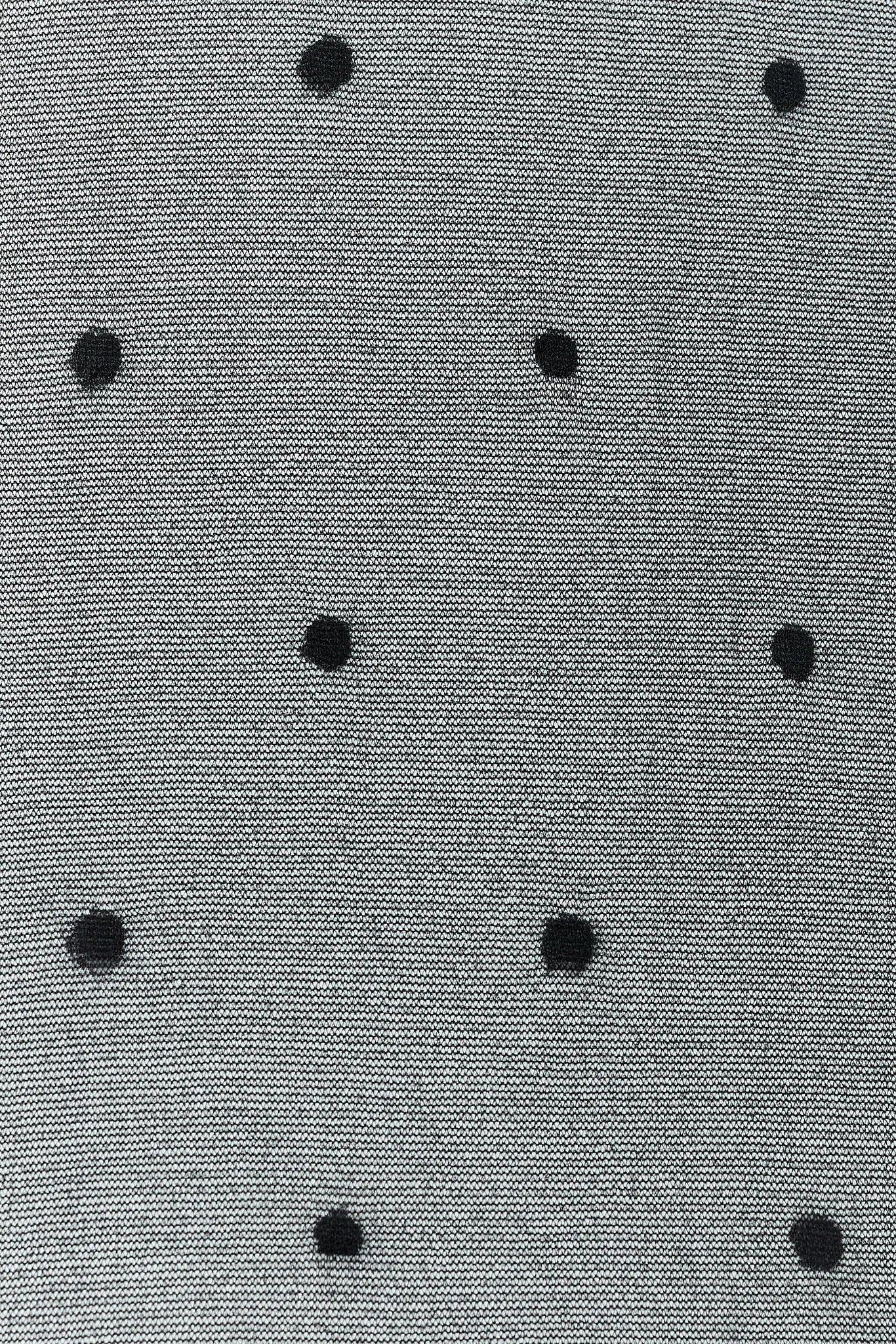 Close-up of a textured fabric with black polka dots