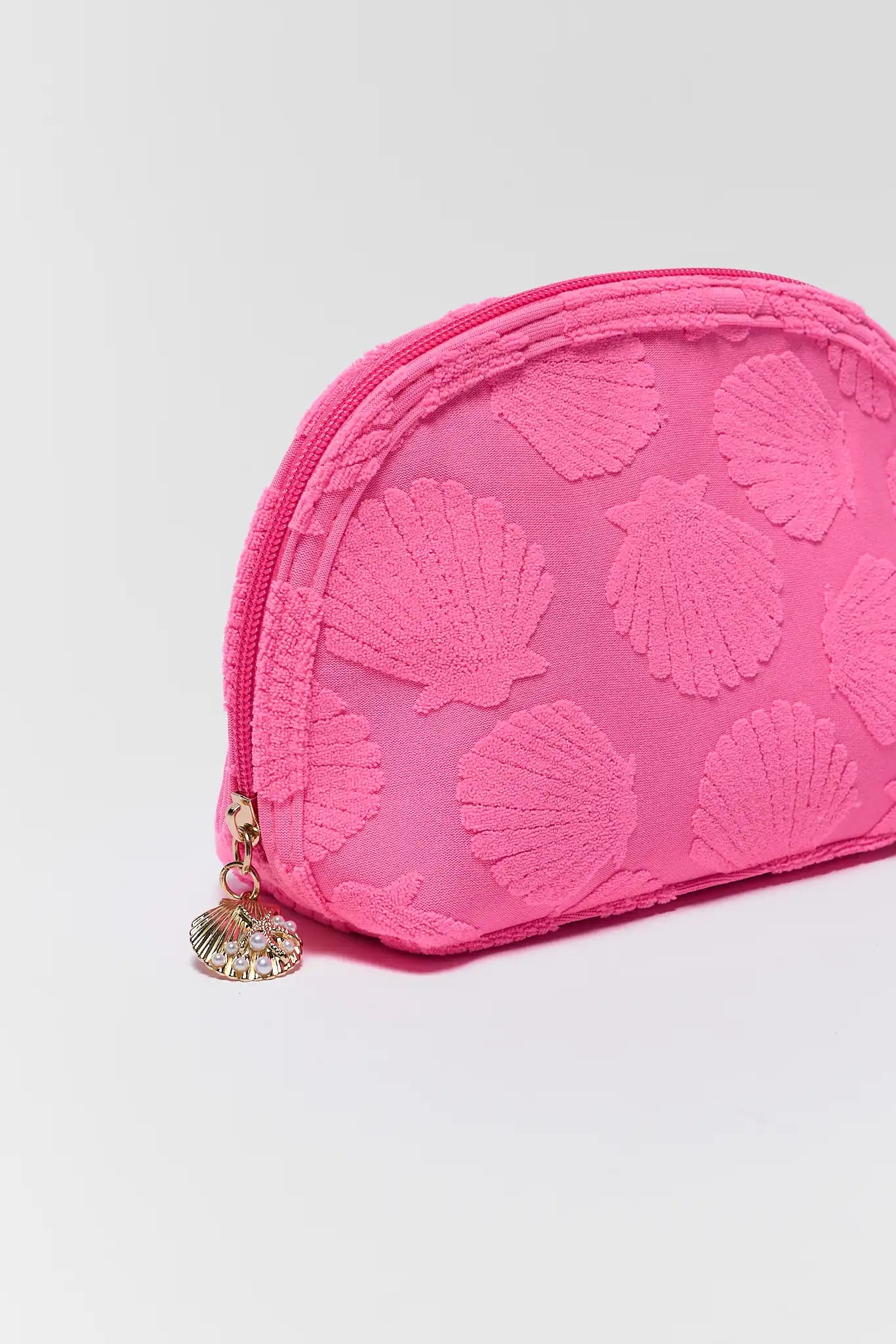 close up Pink pouch with shell pattern on a light gray background