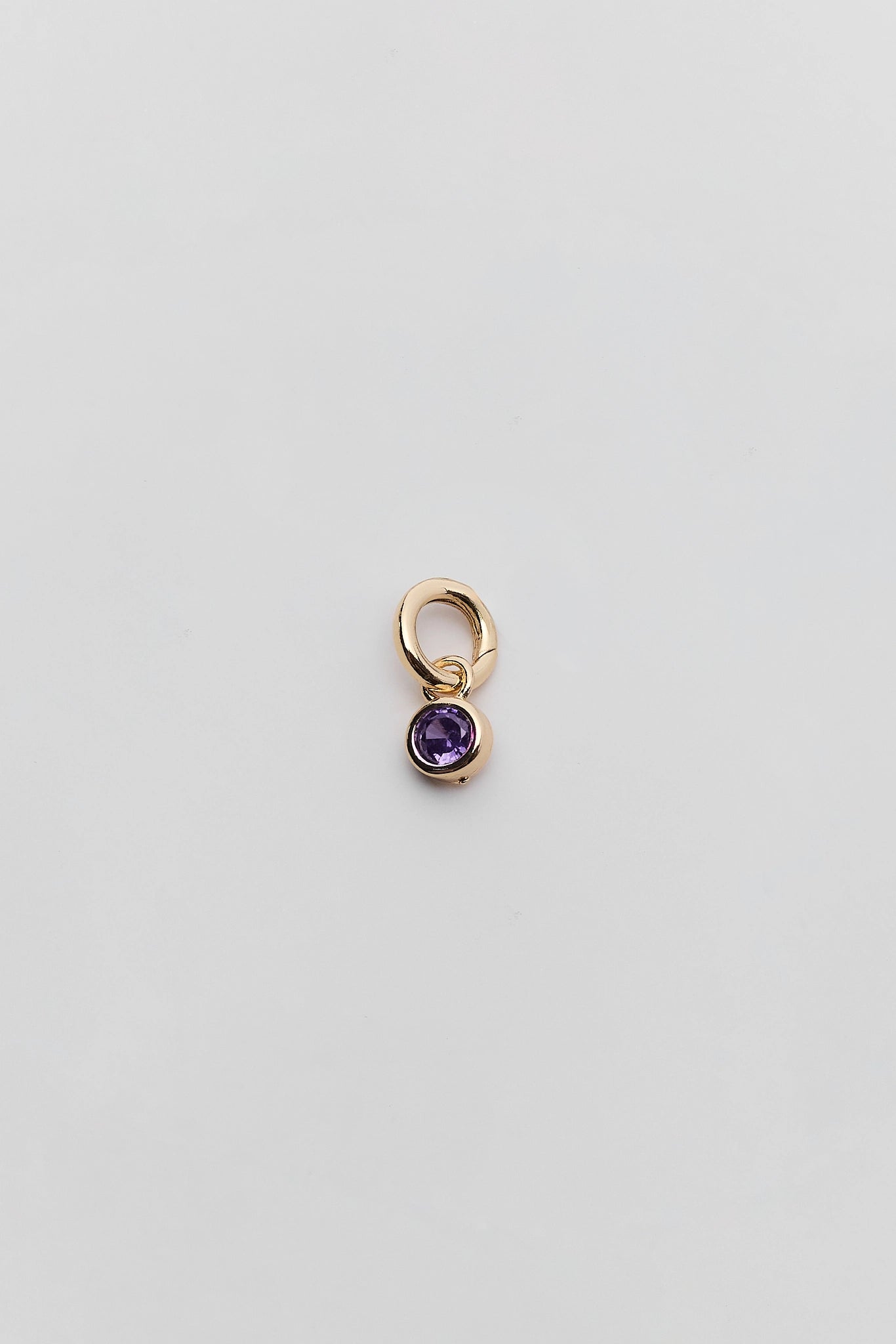 a purple rhinestone charm on a white background