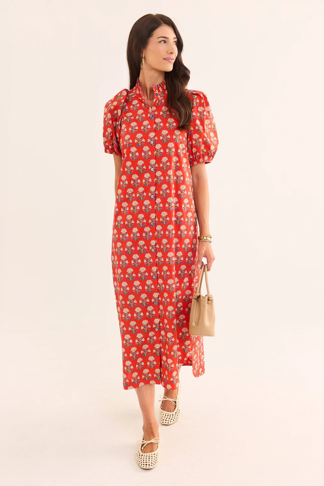 Woman wearing a red floral dress on a beige background lifestyle