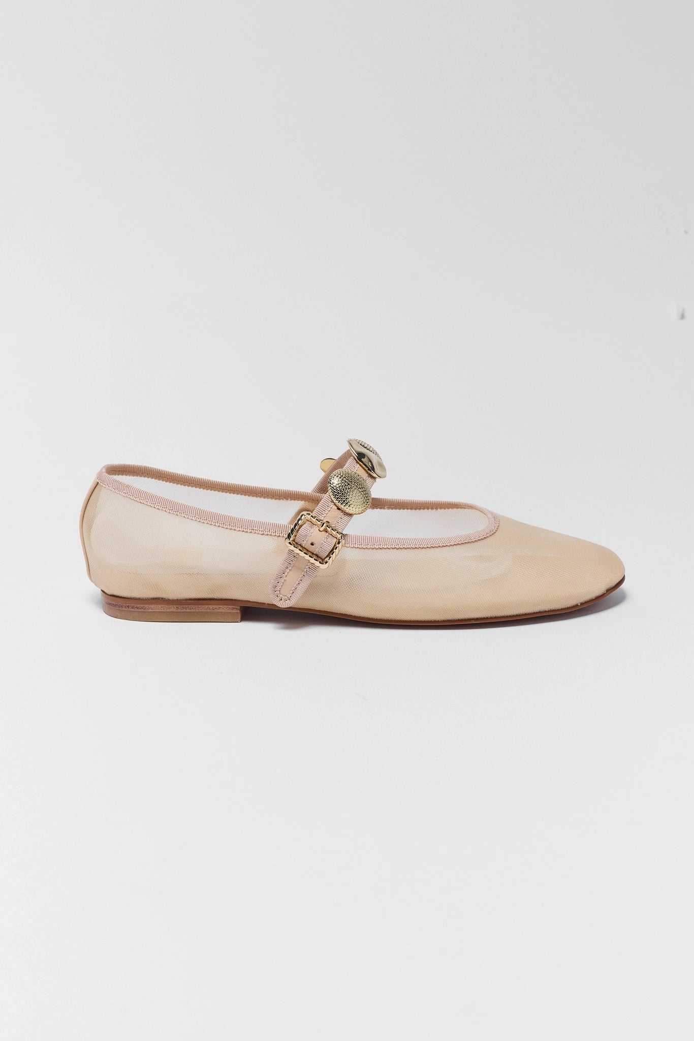 Beige flat shoe with a gold buckle on a white background