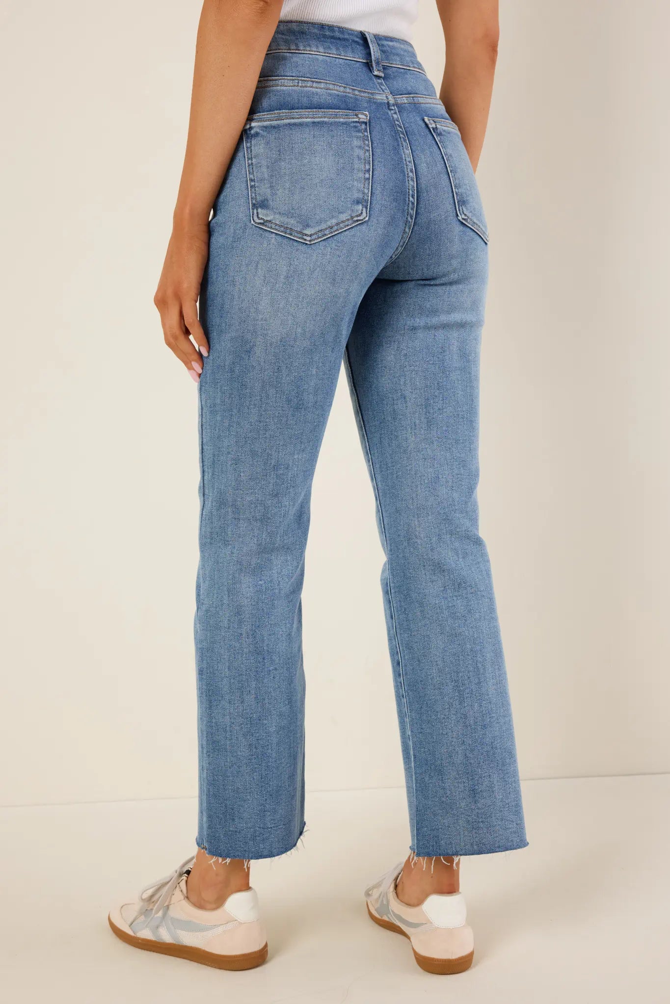 Person wearing light aliyah blue jeans on a plain background