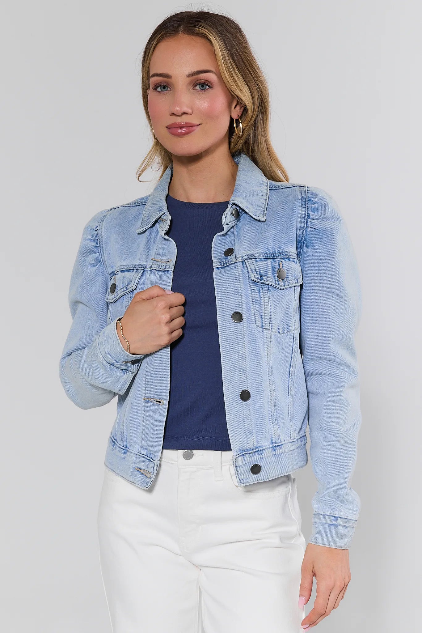 Woman wearing a light blue denim jacket on a white background