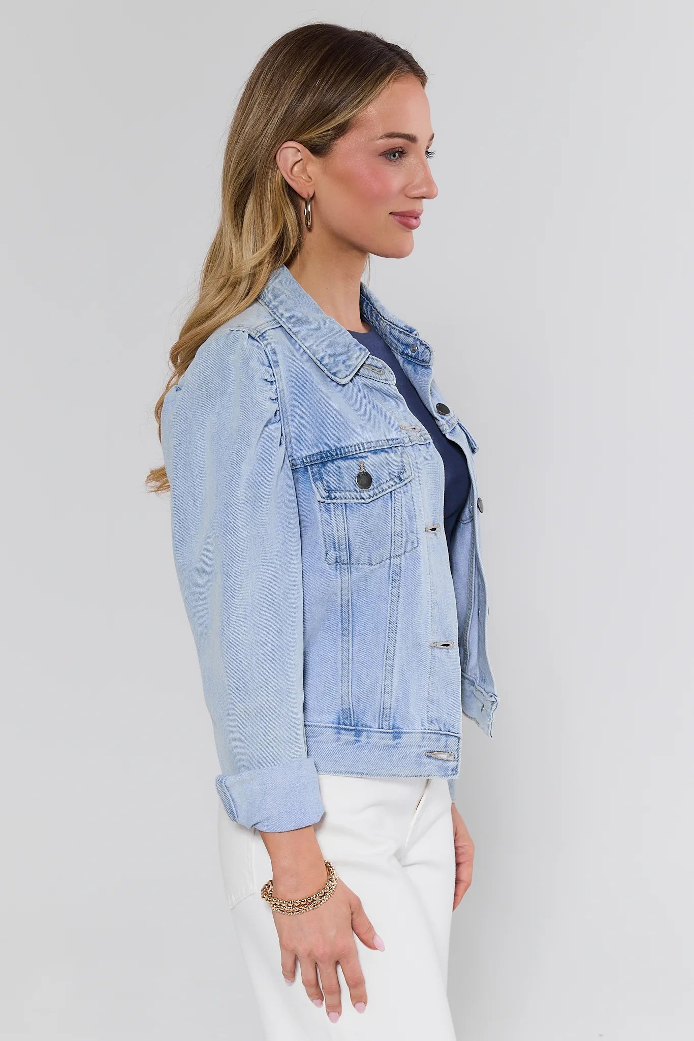 Woman wearing a light blue denim jacket on a background