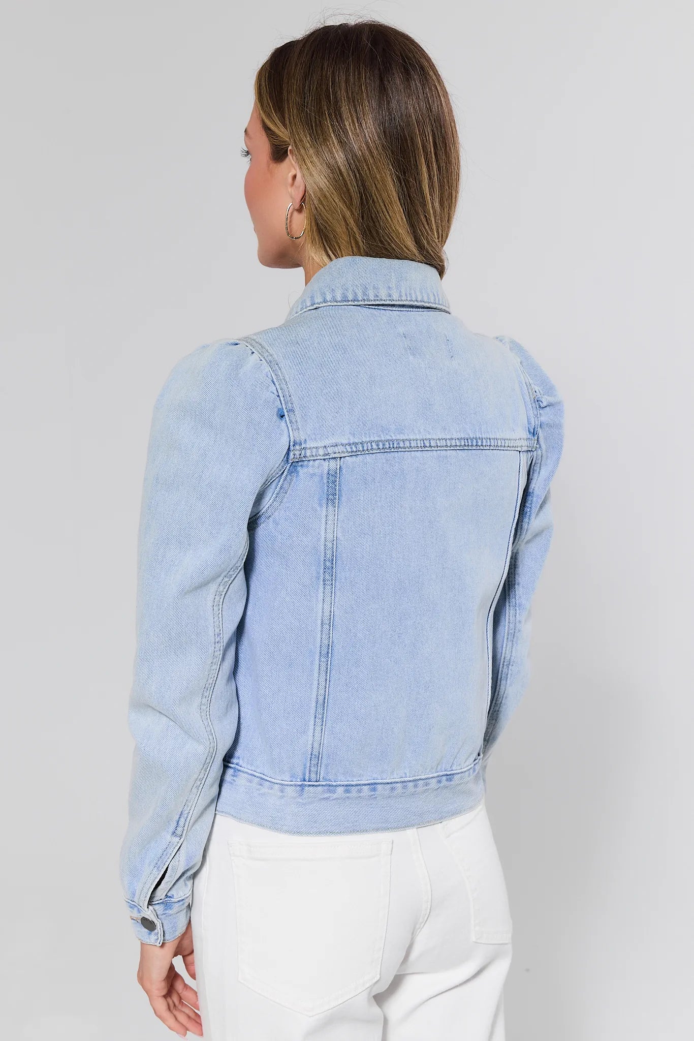 Light blue denim jacket worn by a person on a plain background