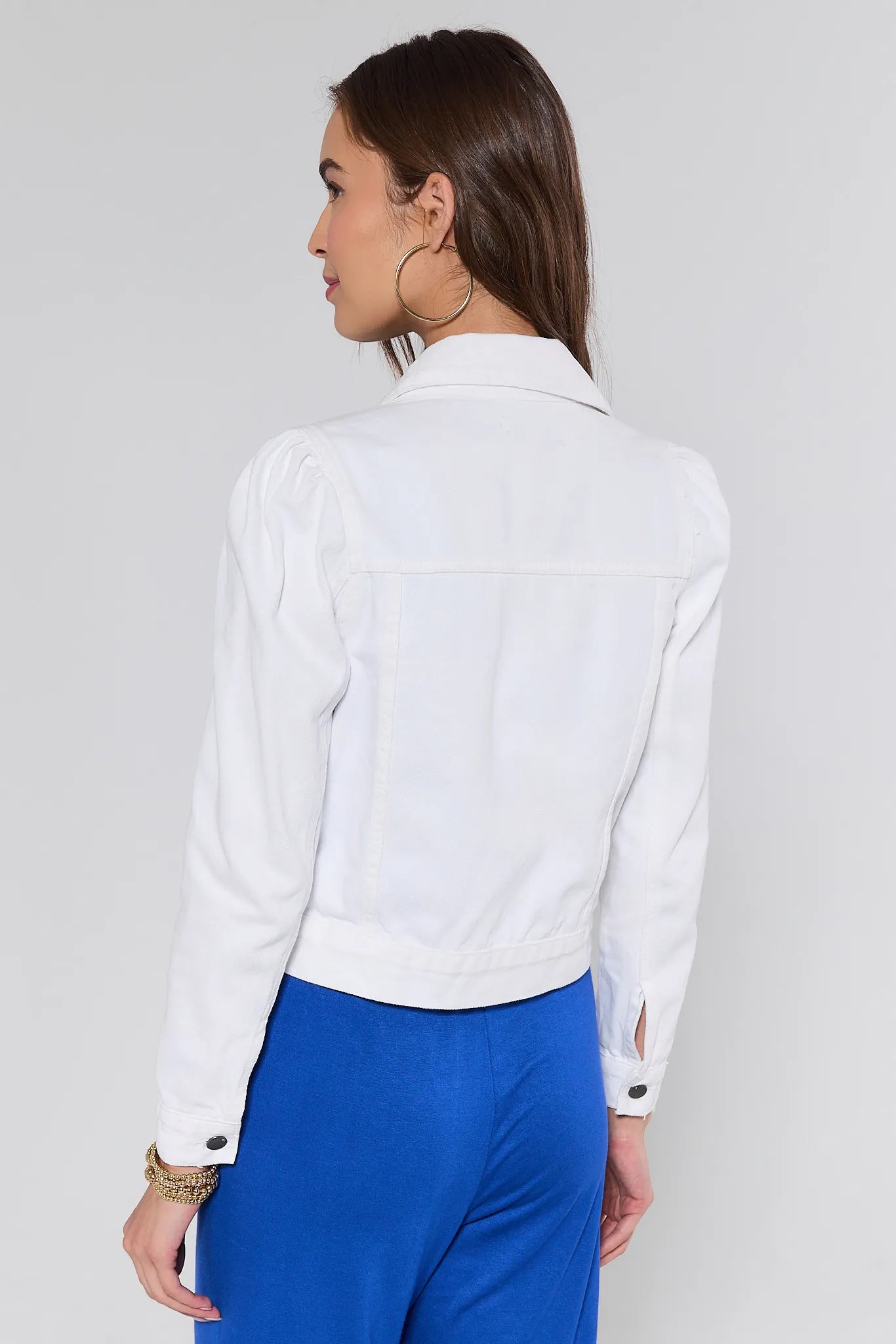 View 4: Woman wearing a white blouse with blue pants on a plain background