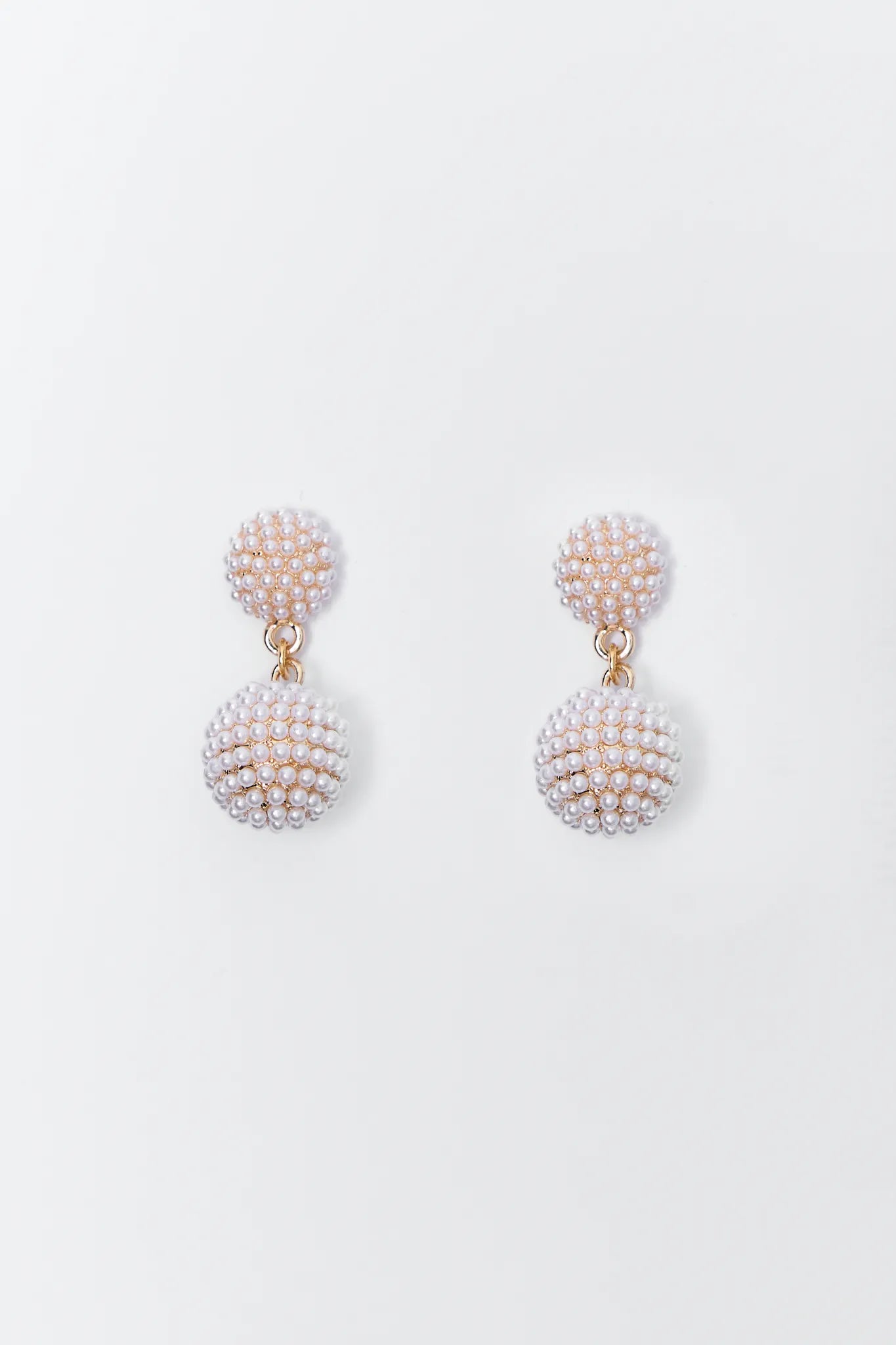 Pair of pearl Talulah earrings on a light gray background