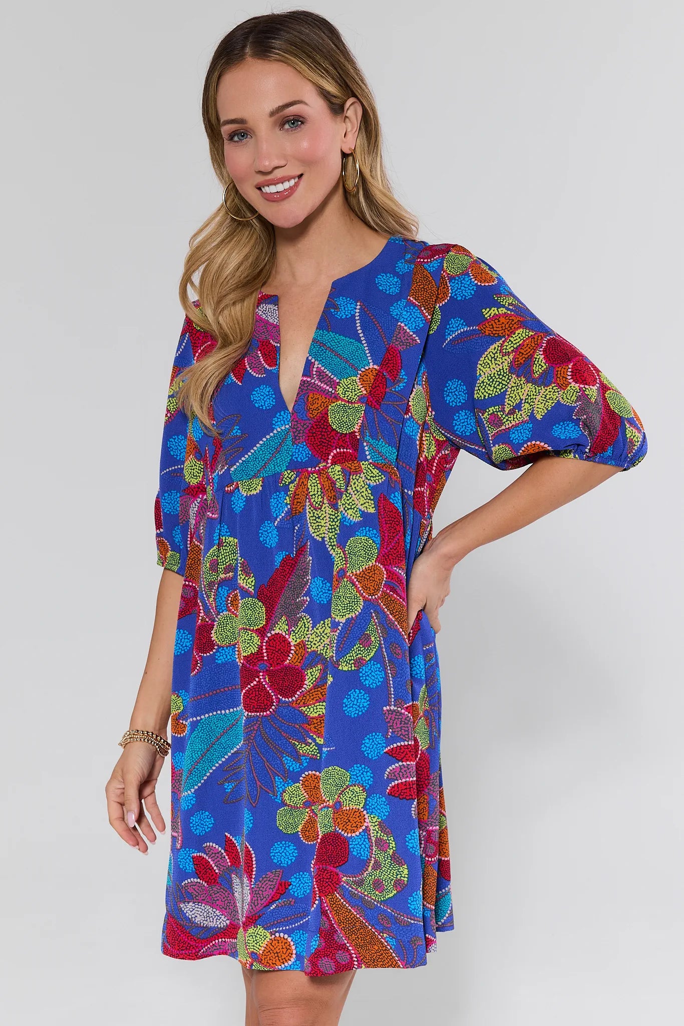 Woman wearing a colorful floral dress on a white background