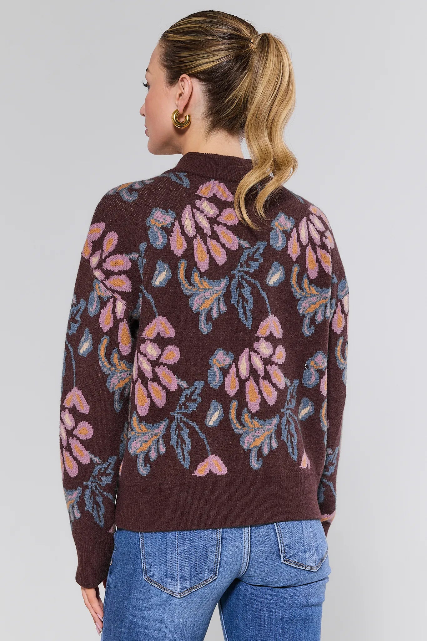 Woman wearing a brown floral-patterned Nancy Sweater
against a white background