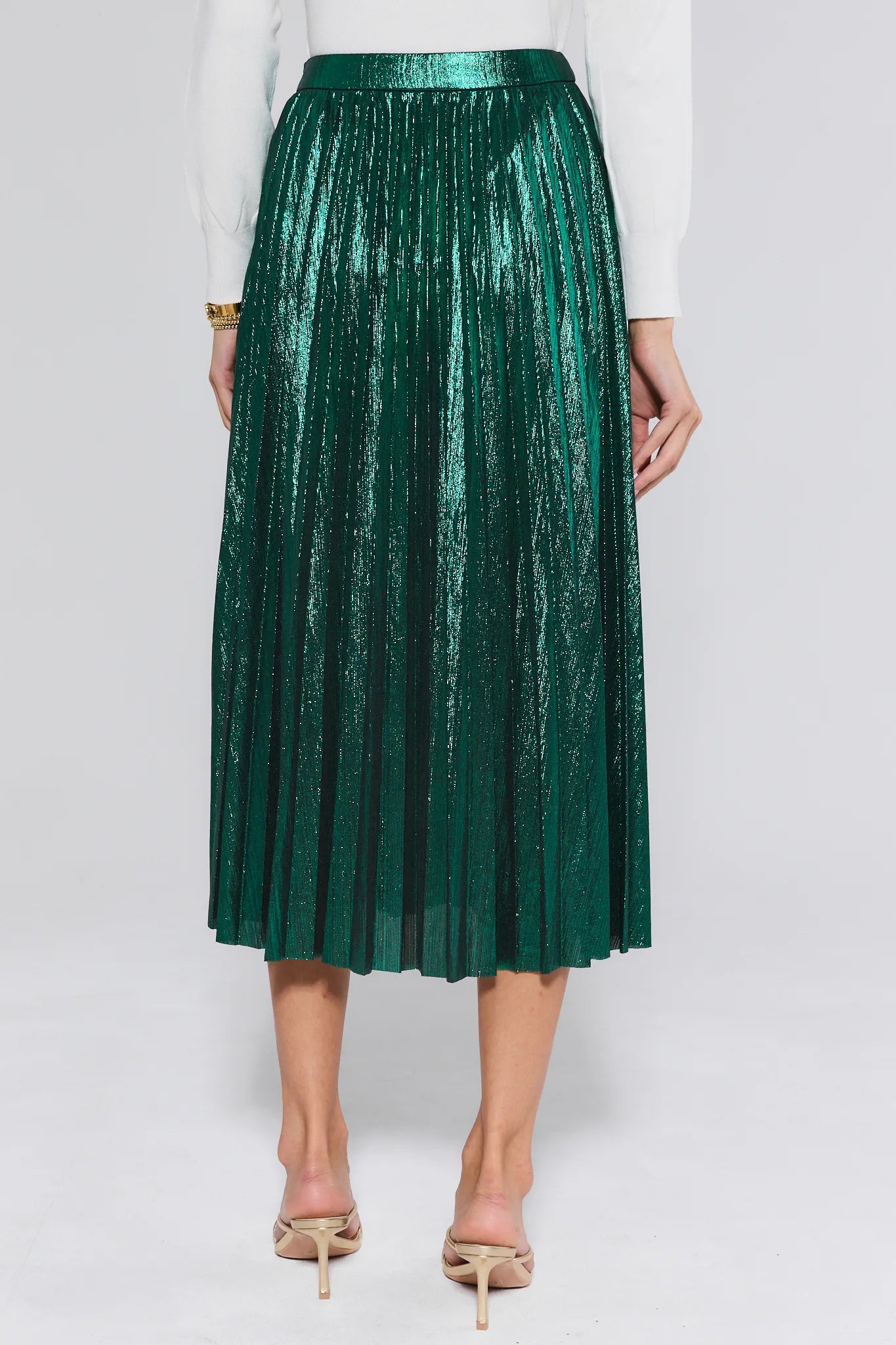 Green pleated skirt worn by a person on a white background