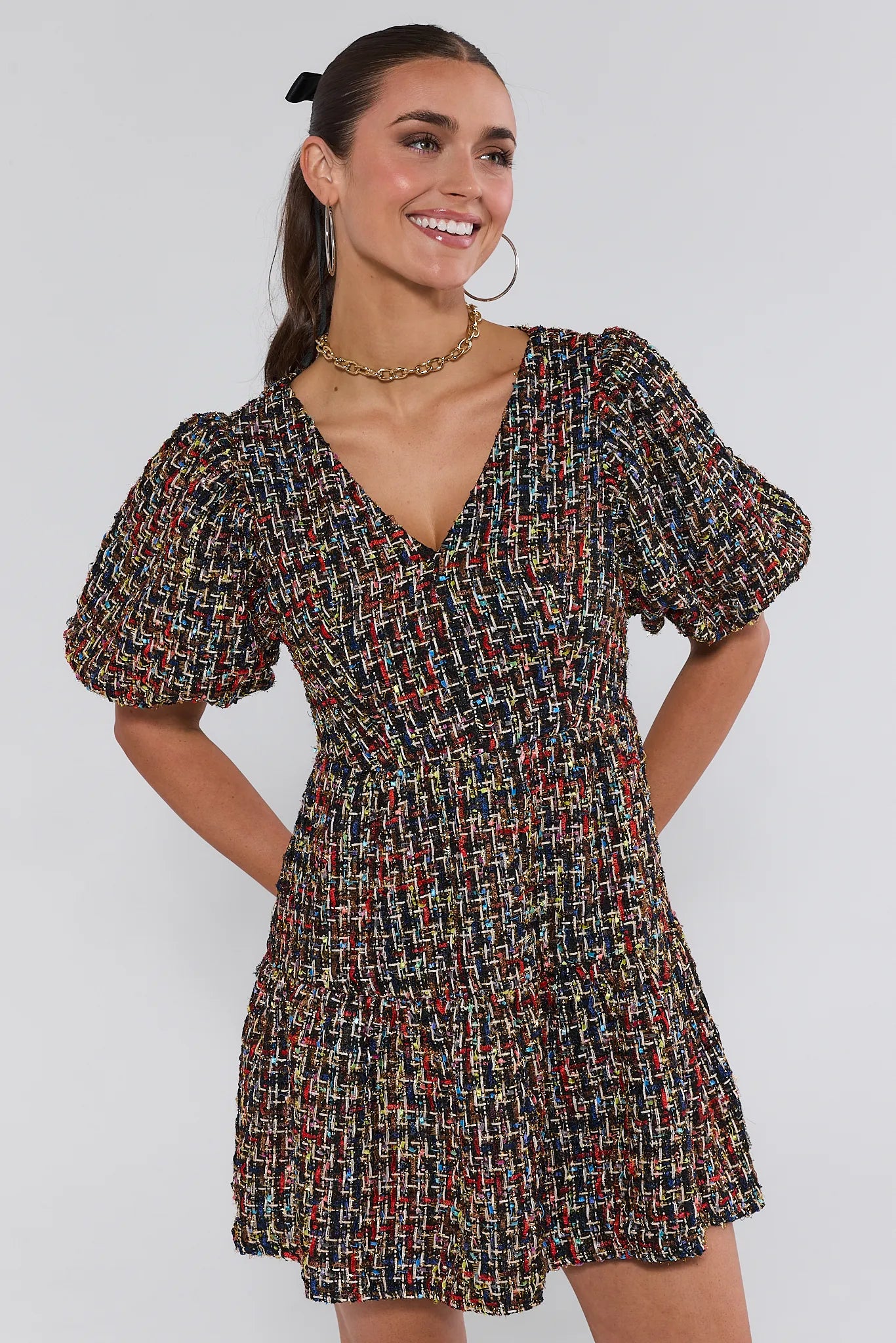 Woman wearing a patterned Cindy Multi Tweed Mini Dress against a plain background