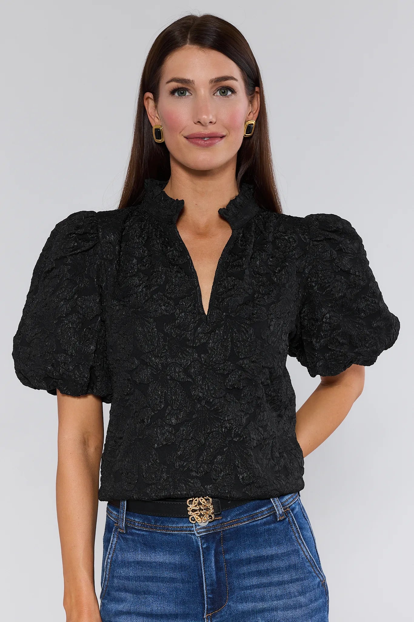 Woman wearing a Teresa Black Floral Top with puffed sleeves against a white background