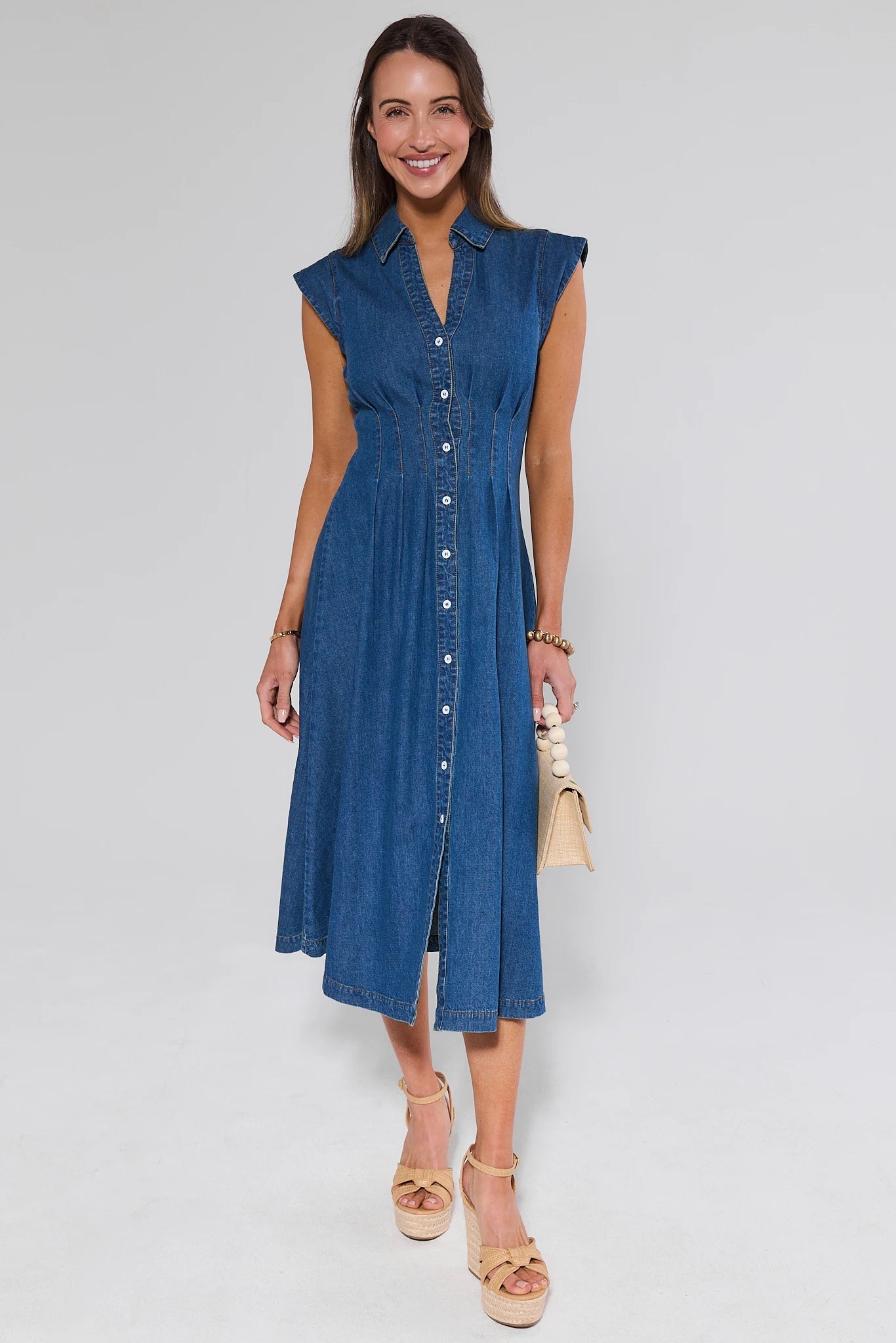 Woman wearing a blue denim dress on a white background