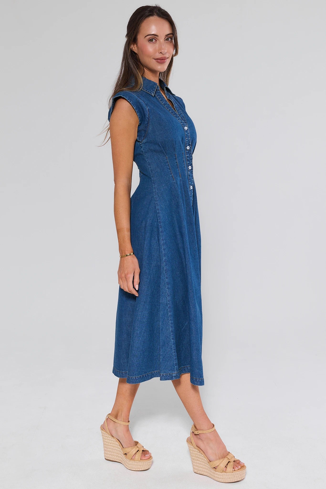 Woman wearing a blue denim dress on a white background