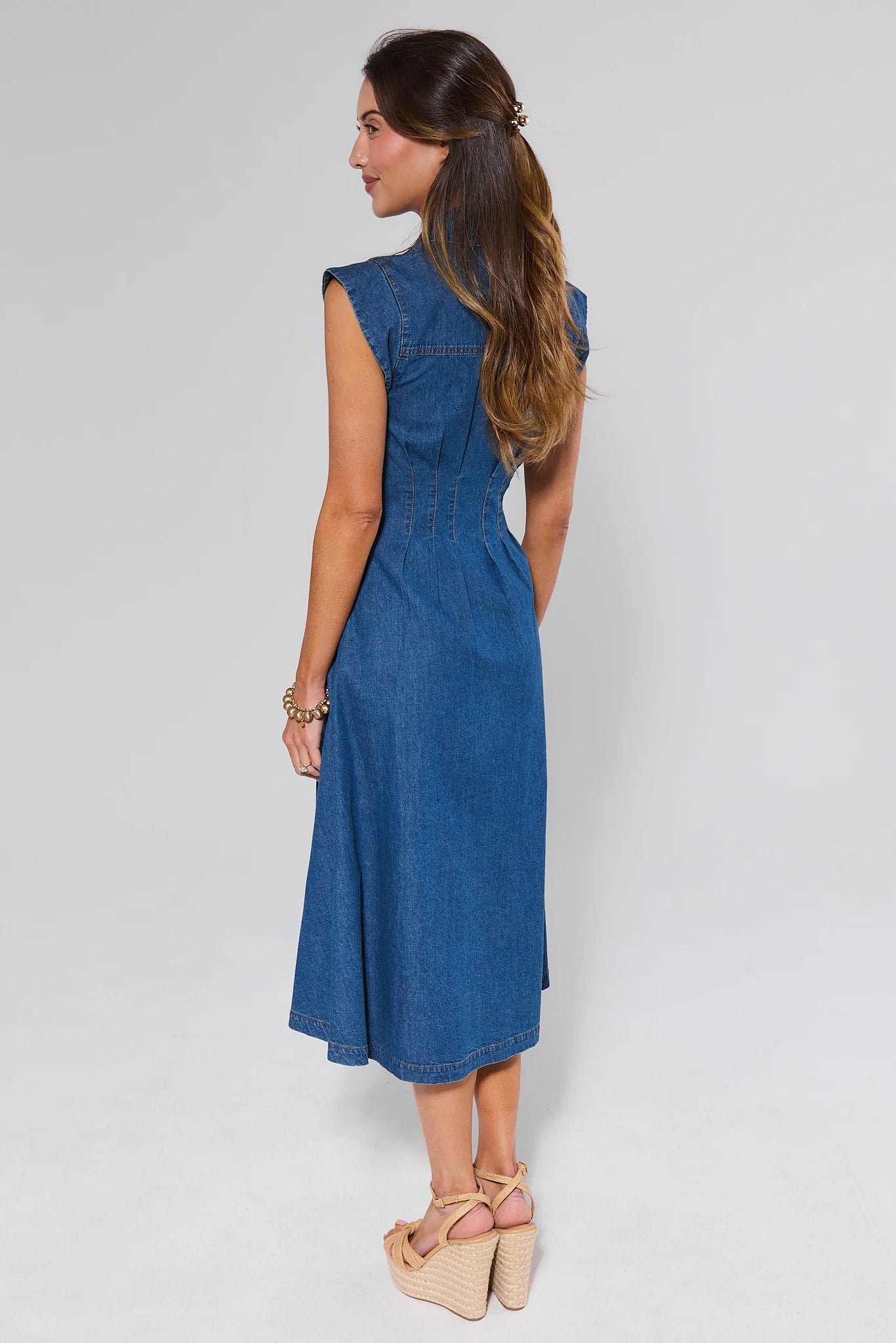 Woman wearing a blue denim dress on a white background