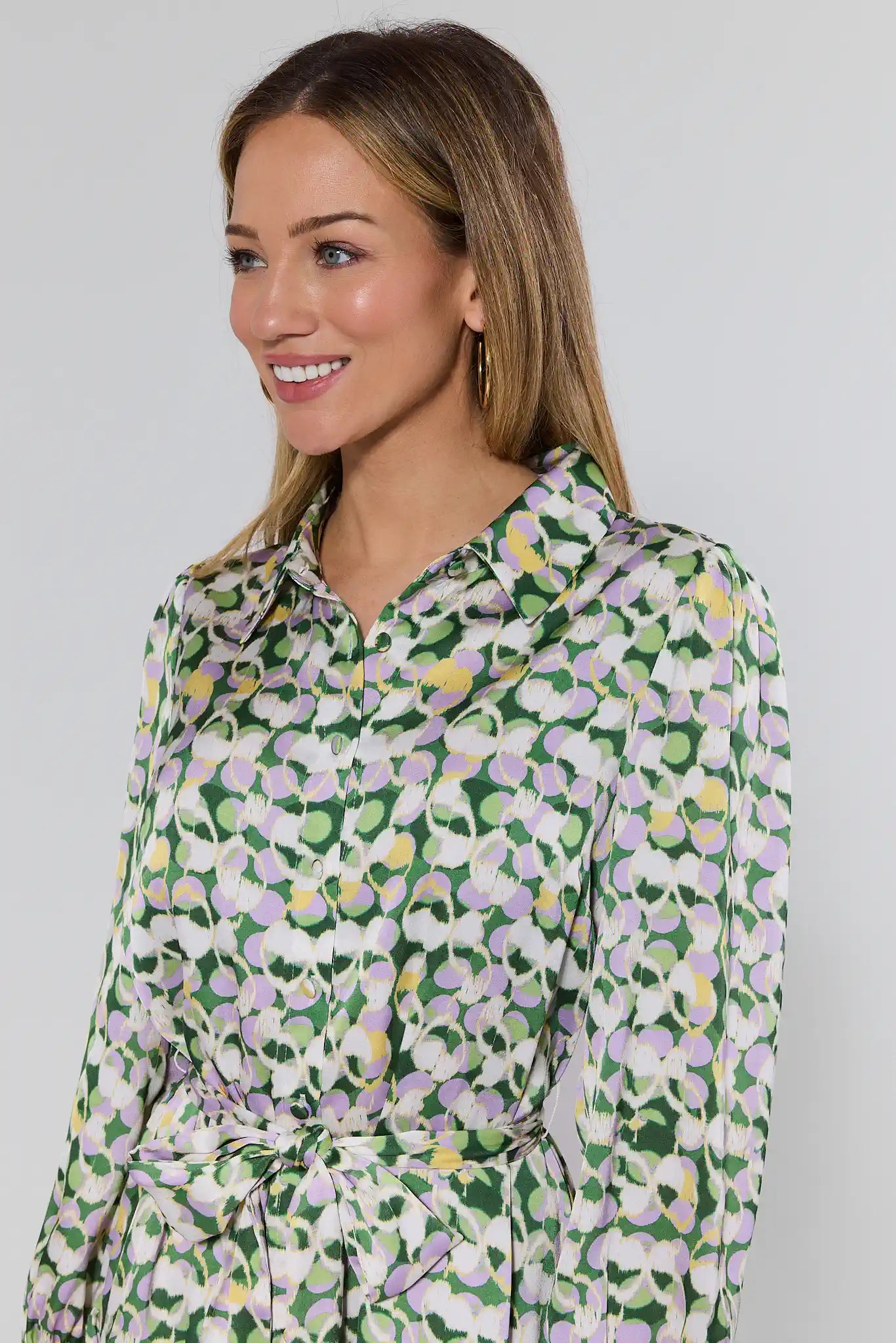 Woman wearing a floral patterned shirt against a plain background