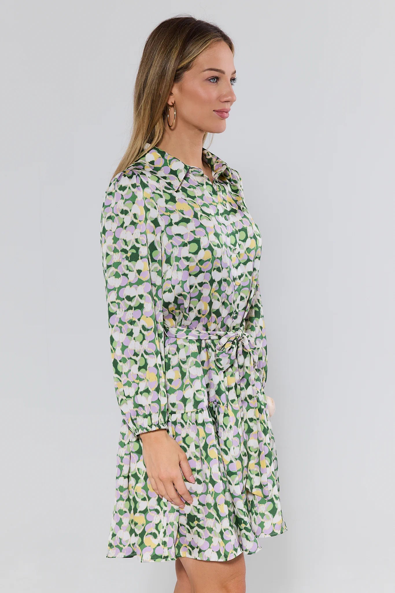 Woman wearing a floral dress against a plain background