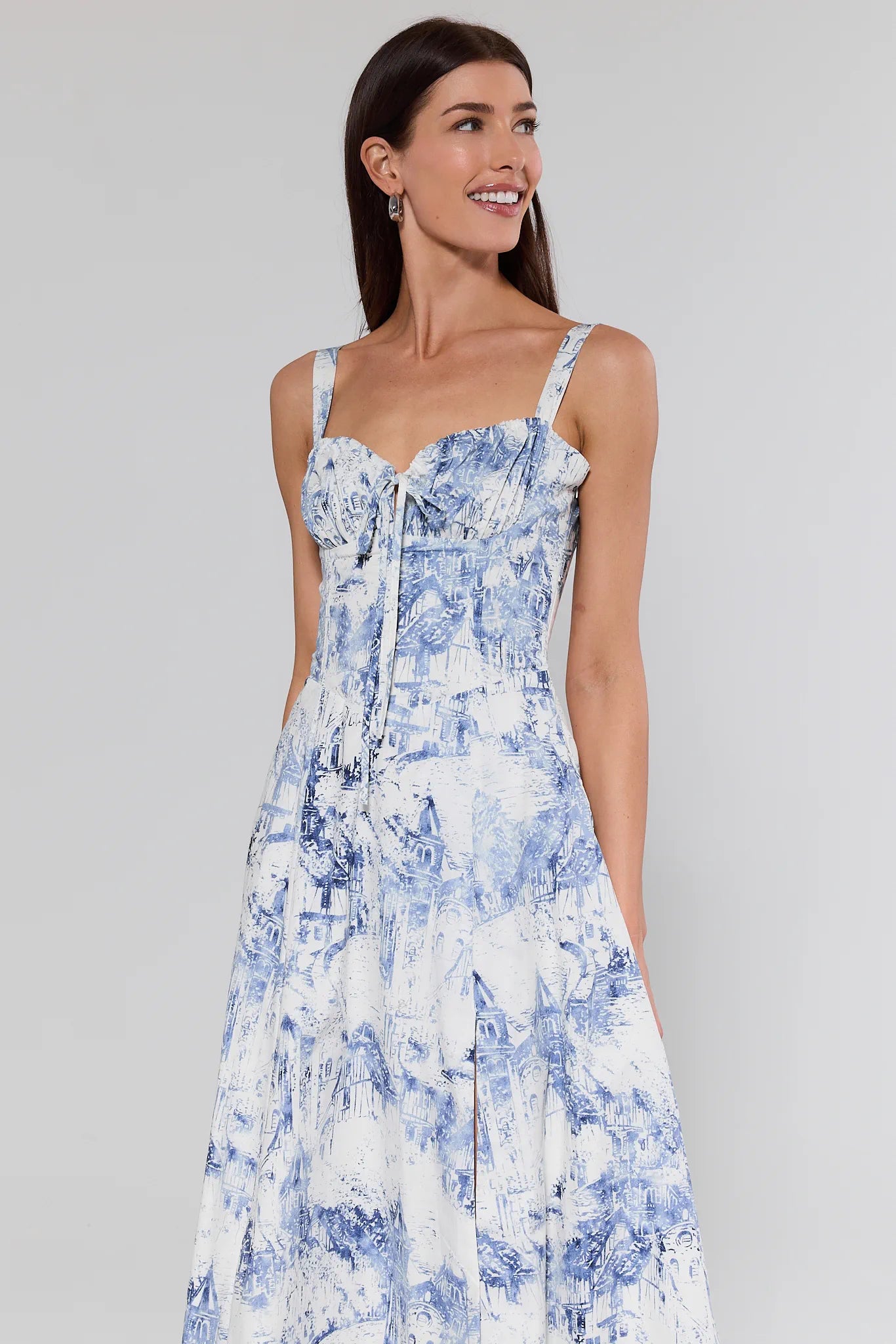 Woman wearing a blue and white floral dress against a gray background