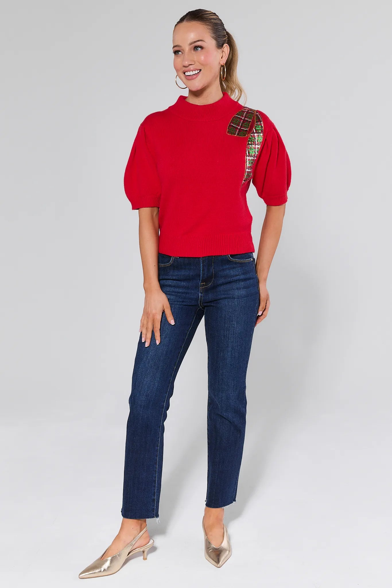 Woman wearing a Eve Red Sequin Bow Sweater on a plain background