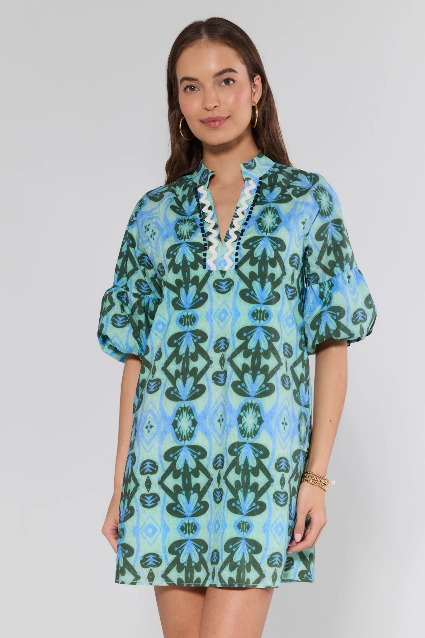 Woman wearing a blue and green patterned dress on a background