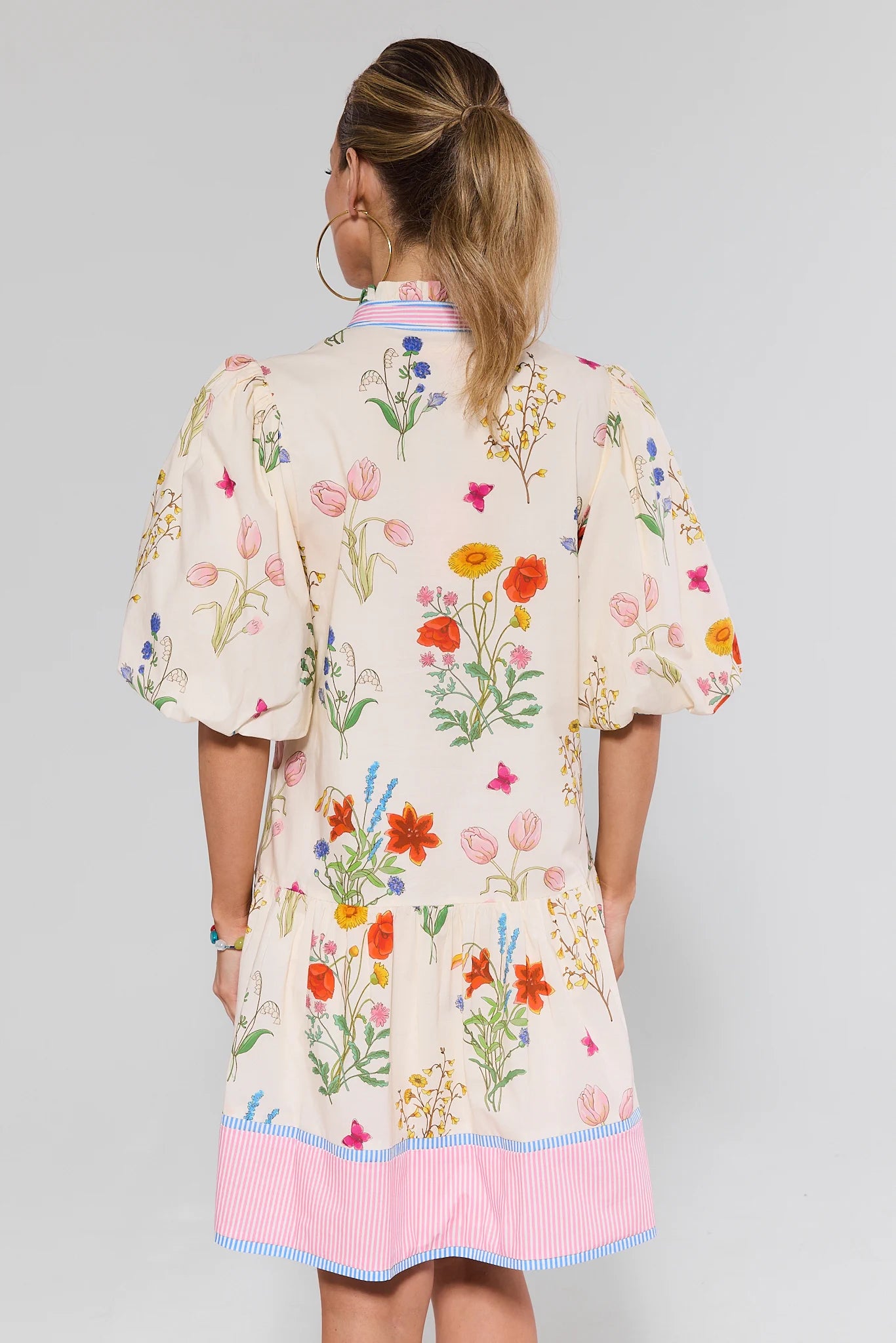 Woman wearing a floral dress with a plain background