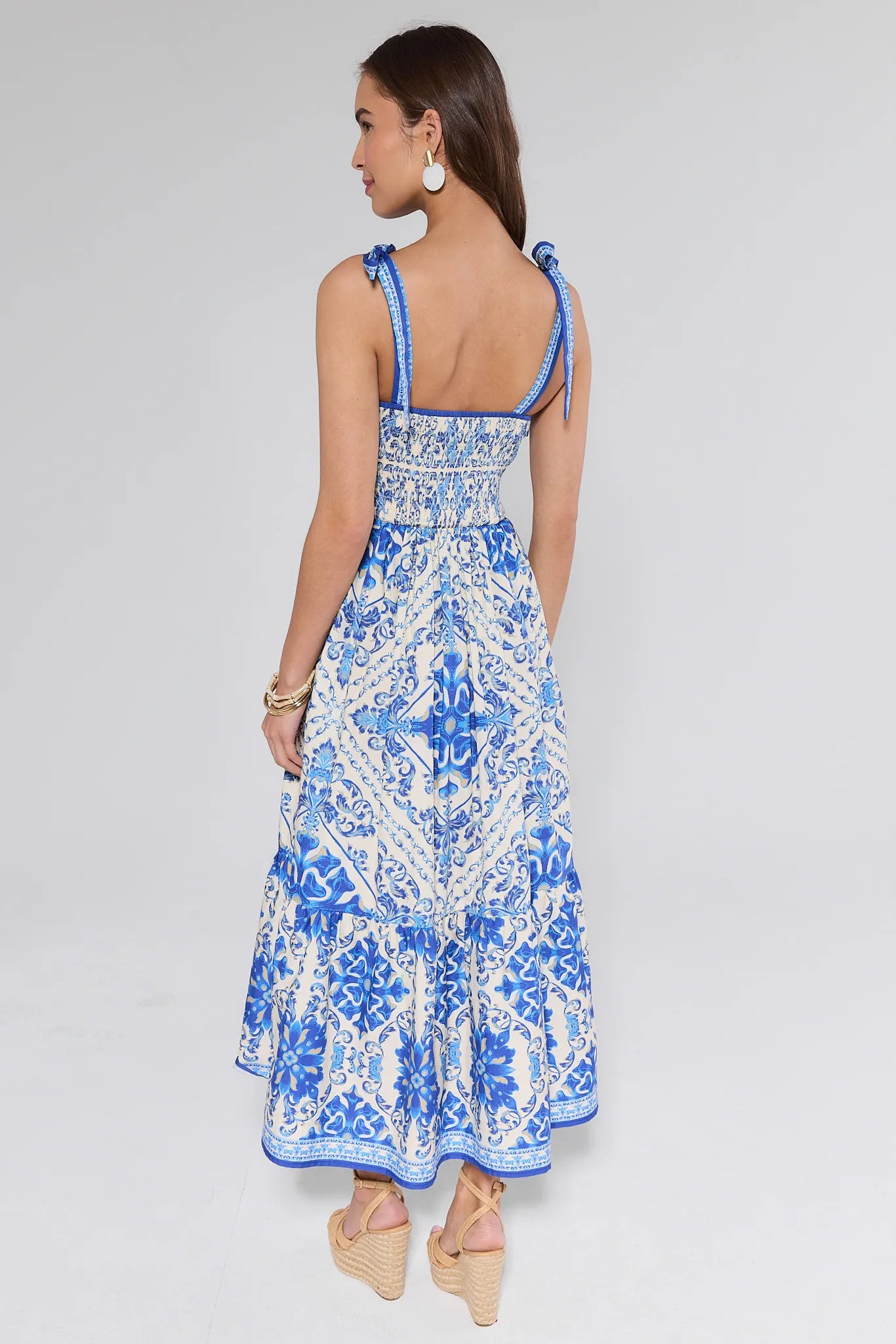 Woman wearing a patterned dress on a gray background