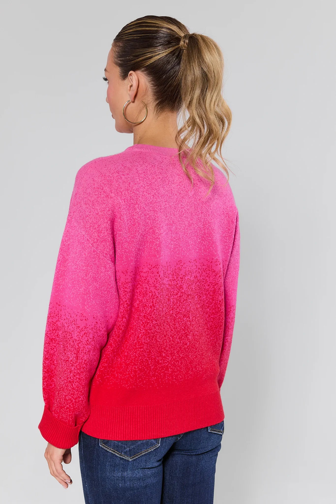 Woman wearing a Juliet Ombre Knit Sweater and blue jeans on a plain background