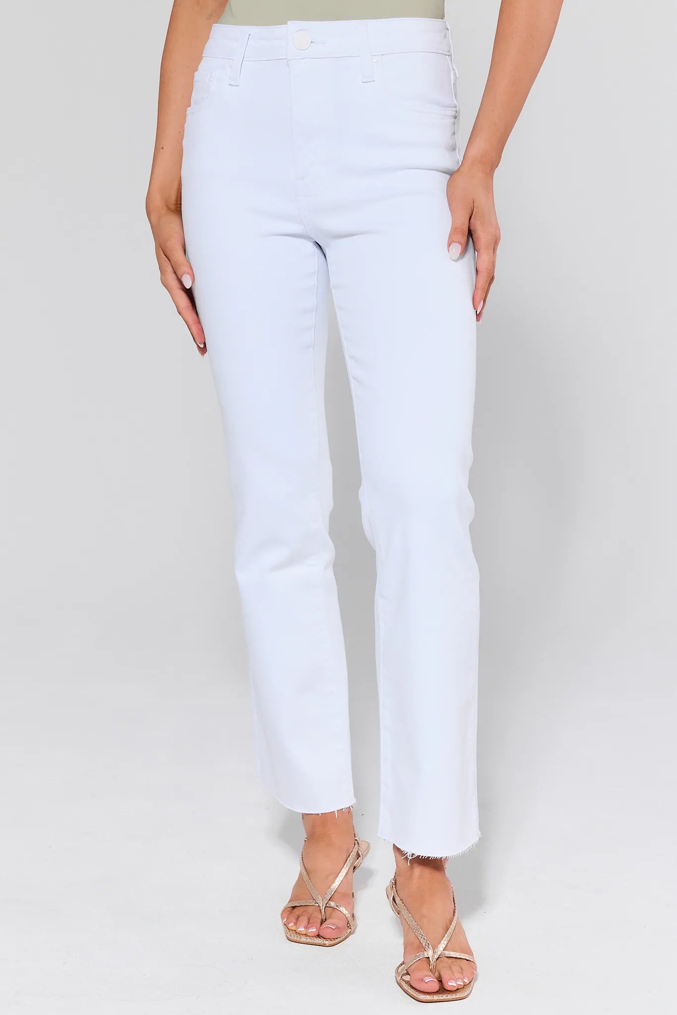 White pants worn by a person on a plain background