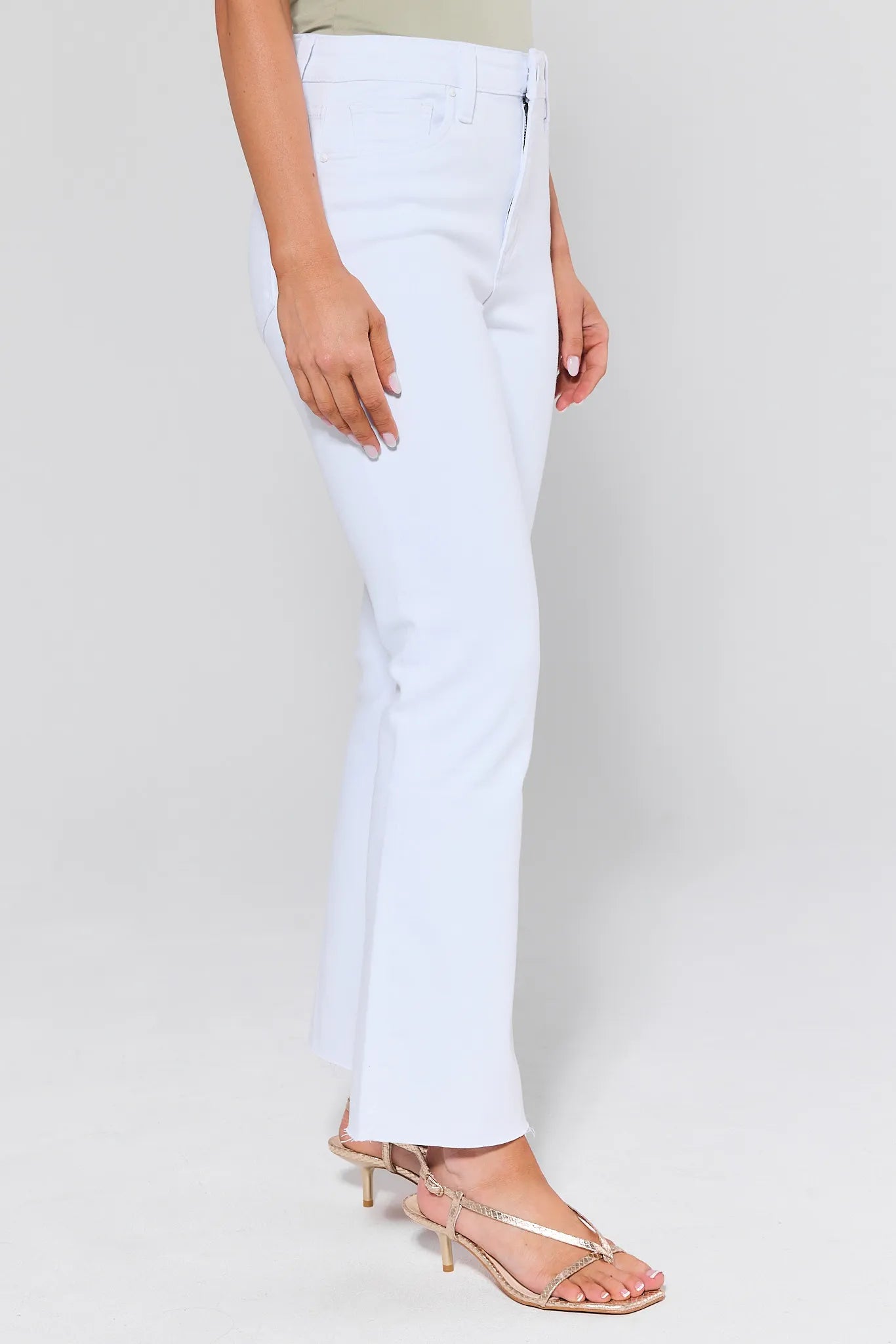 White jeans worn by a person on a plain background