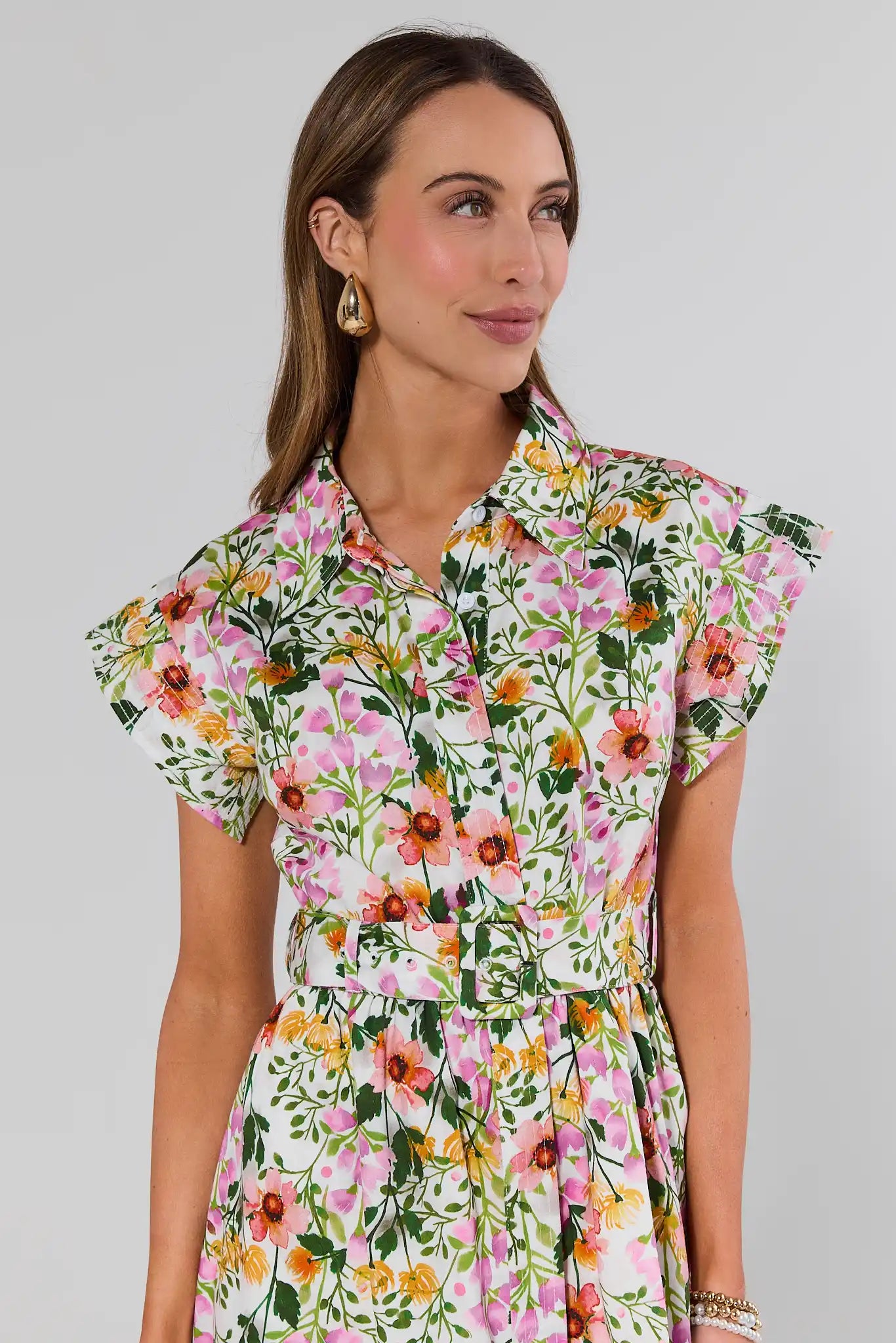 close up Woman wearing a floral dress against a plain background