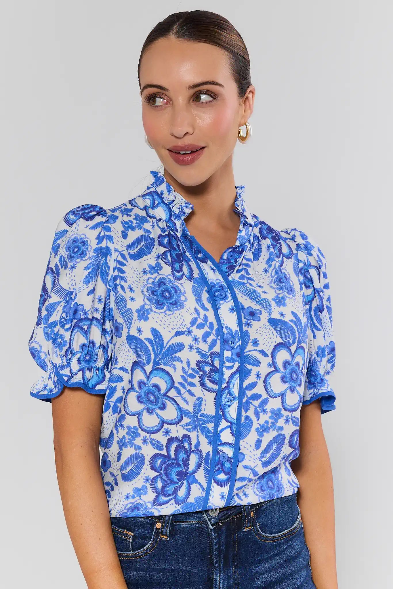 Woman wearing a blue floral blouse against a plain background