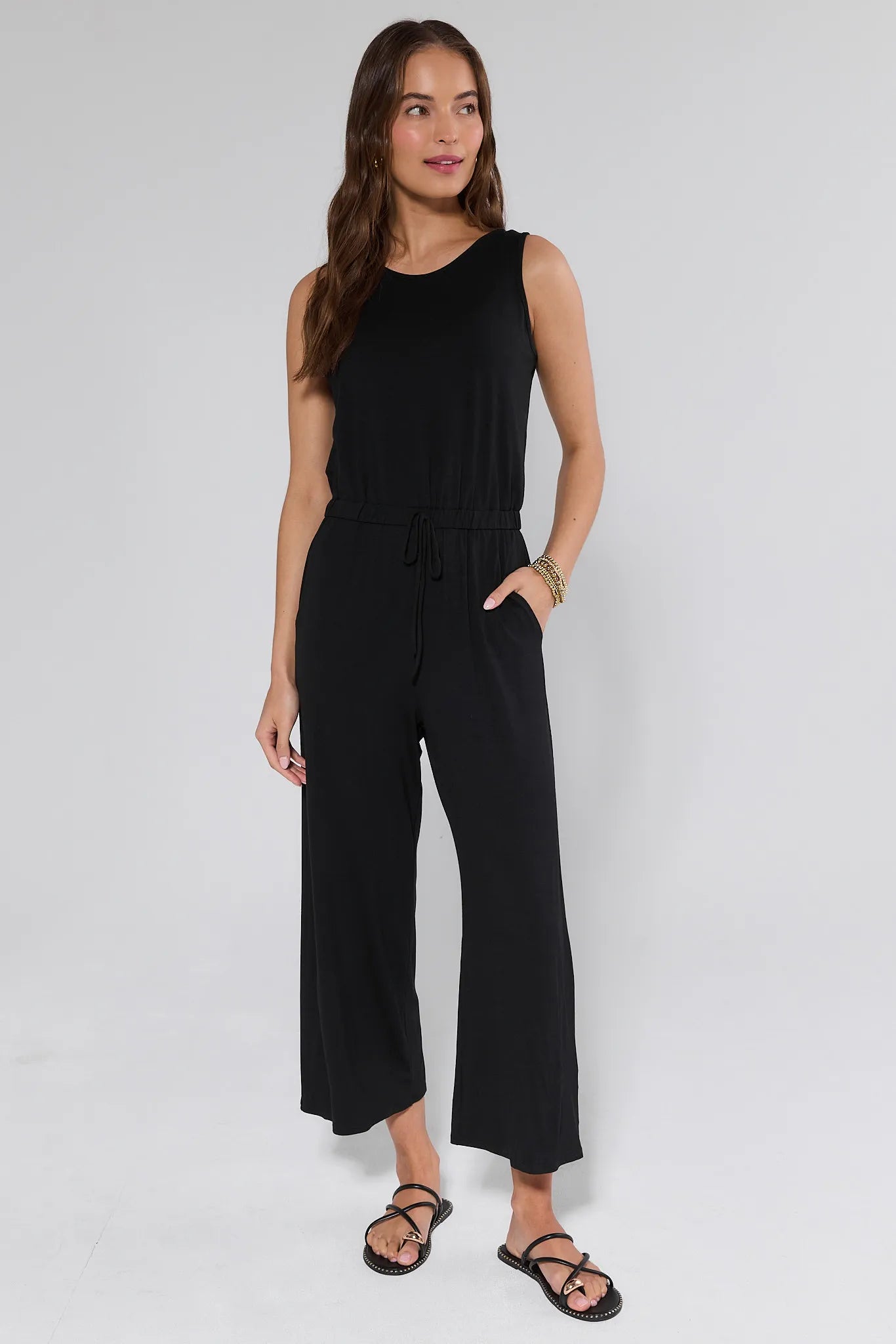 Woman wearing a black jumpsuit on a white background