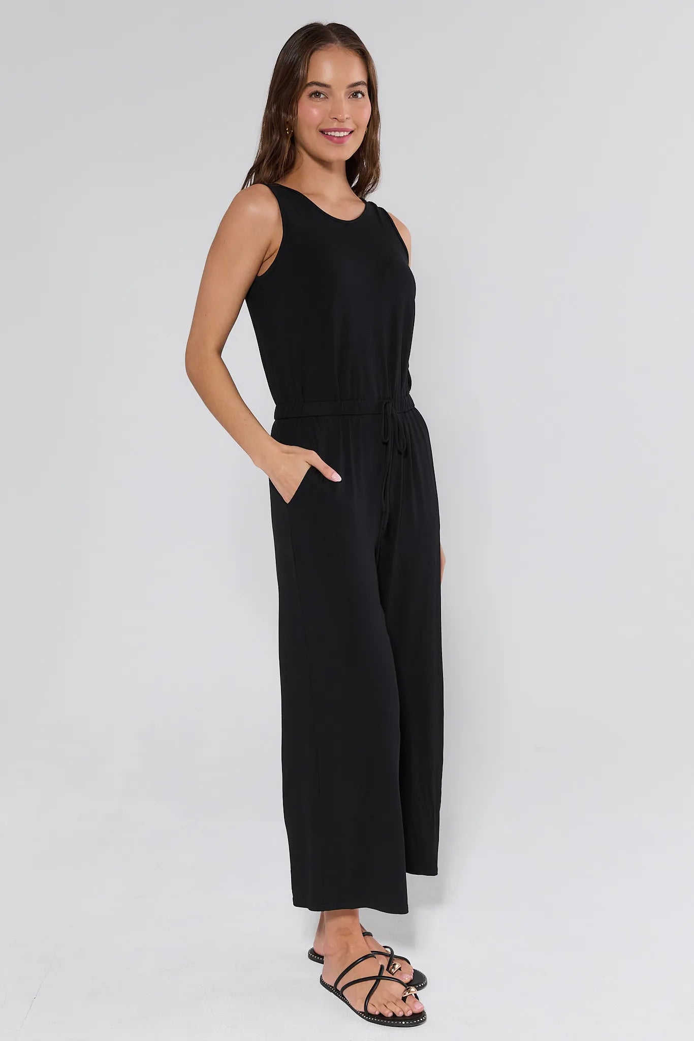 Woman wearing a sleeveless jumpsuit on a white background