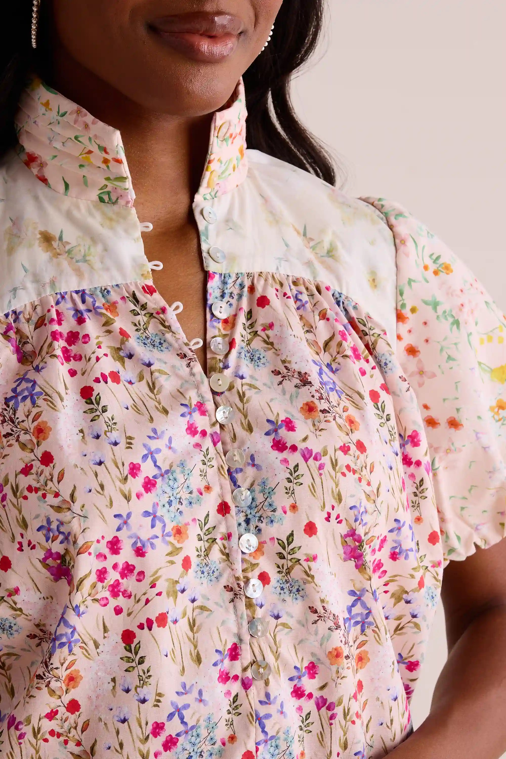 Margie Floral Print Puff Sleeve Top features a ditsy floral print, mandarin collar, mother-of-pearl buttons, and puffed short sleeves, ideal for versatile styling.