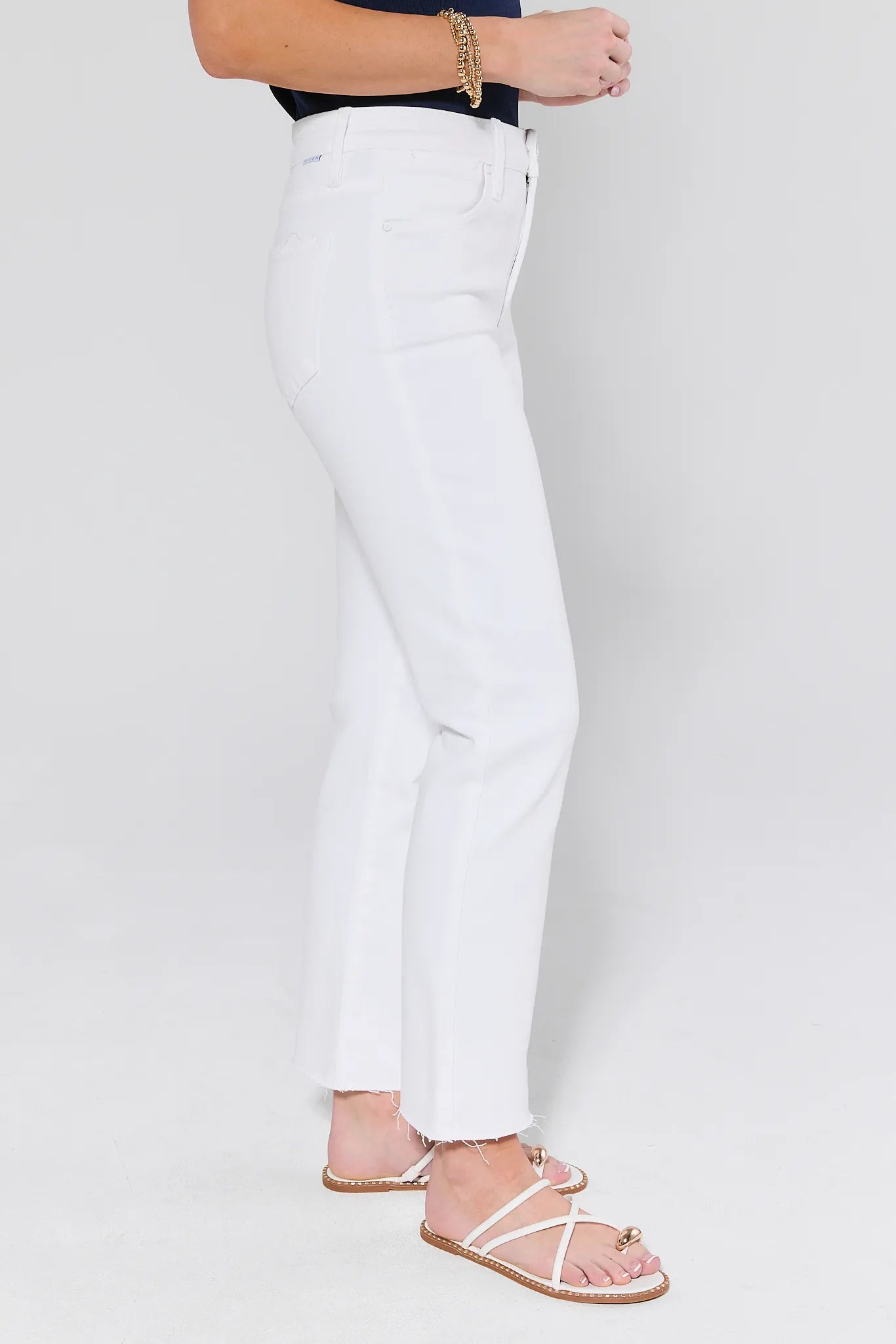 Person wearing white pants on a plain background