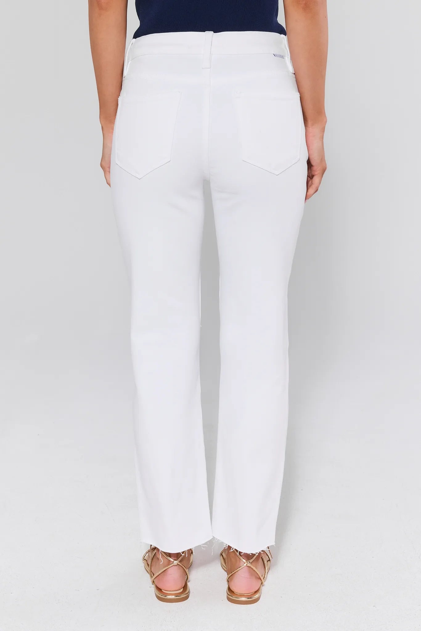 White pants worn by a person on a white background