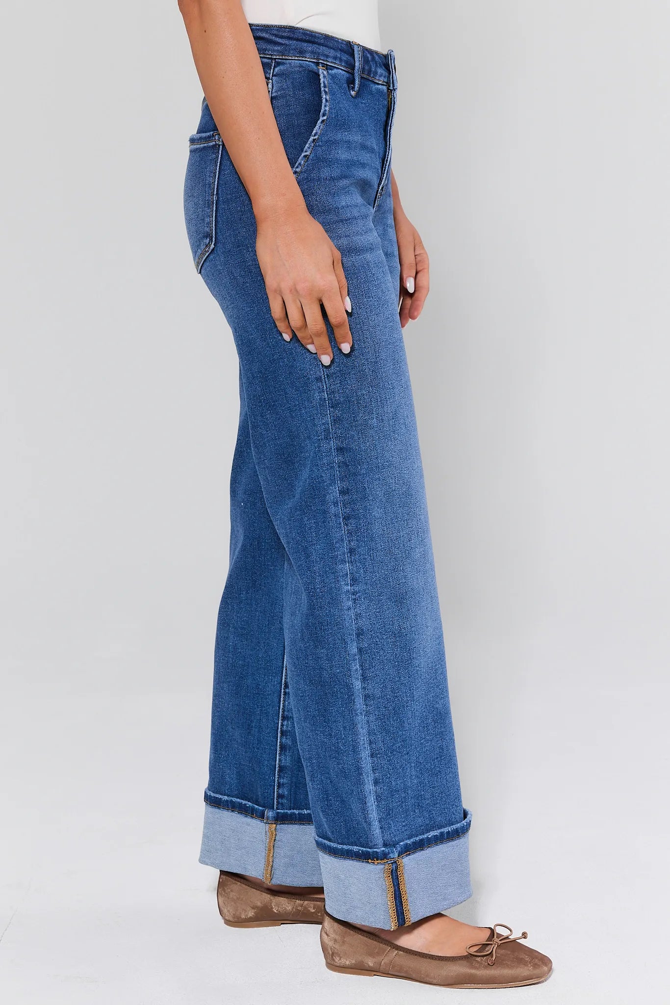 Blue jeans worn by a person on a white background