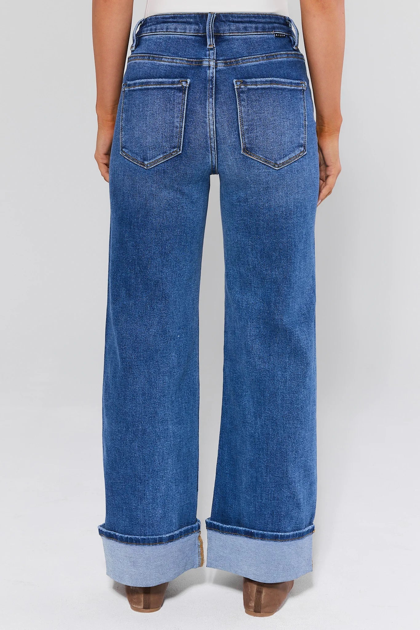 Blue jeans worn by a person on a white background