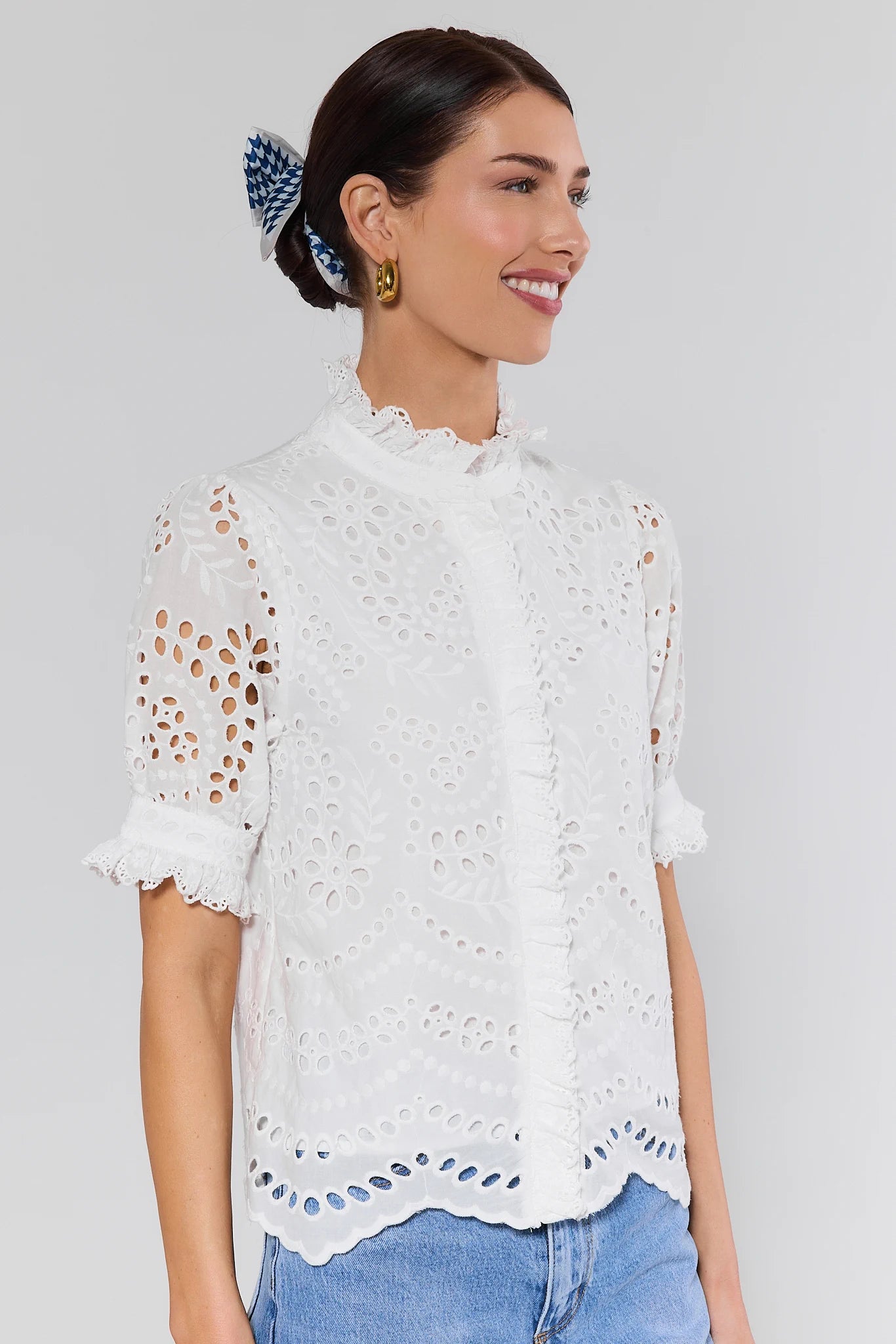 Woman wearing a white lace blouse on a plain background