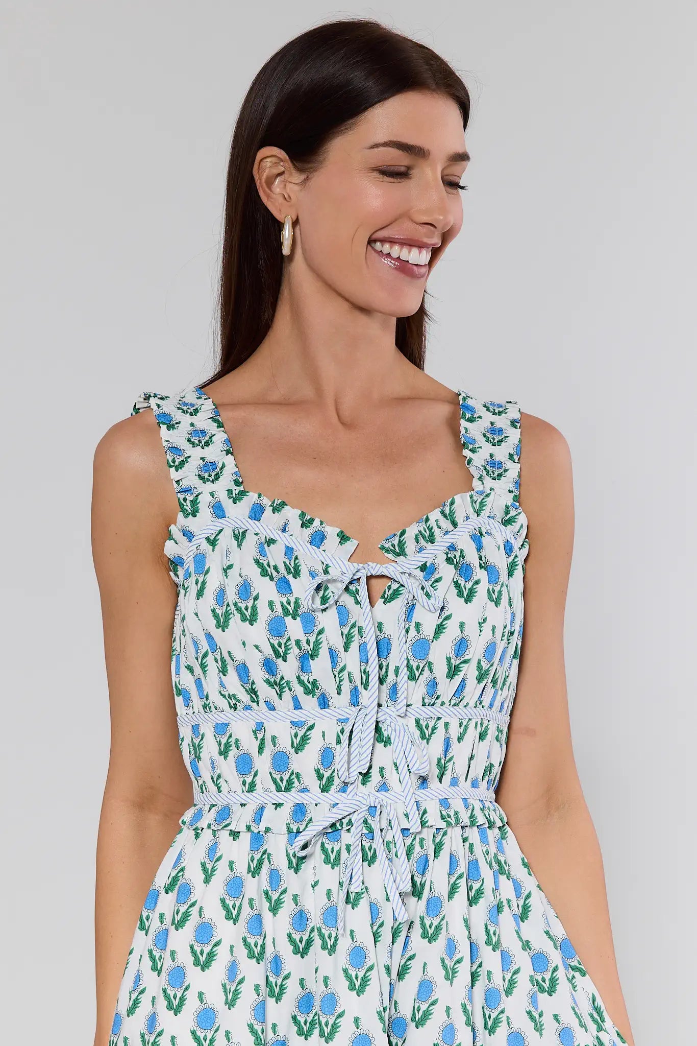 Woman wearing a floral dress against a plain background