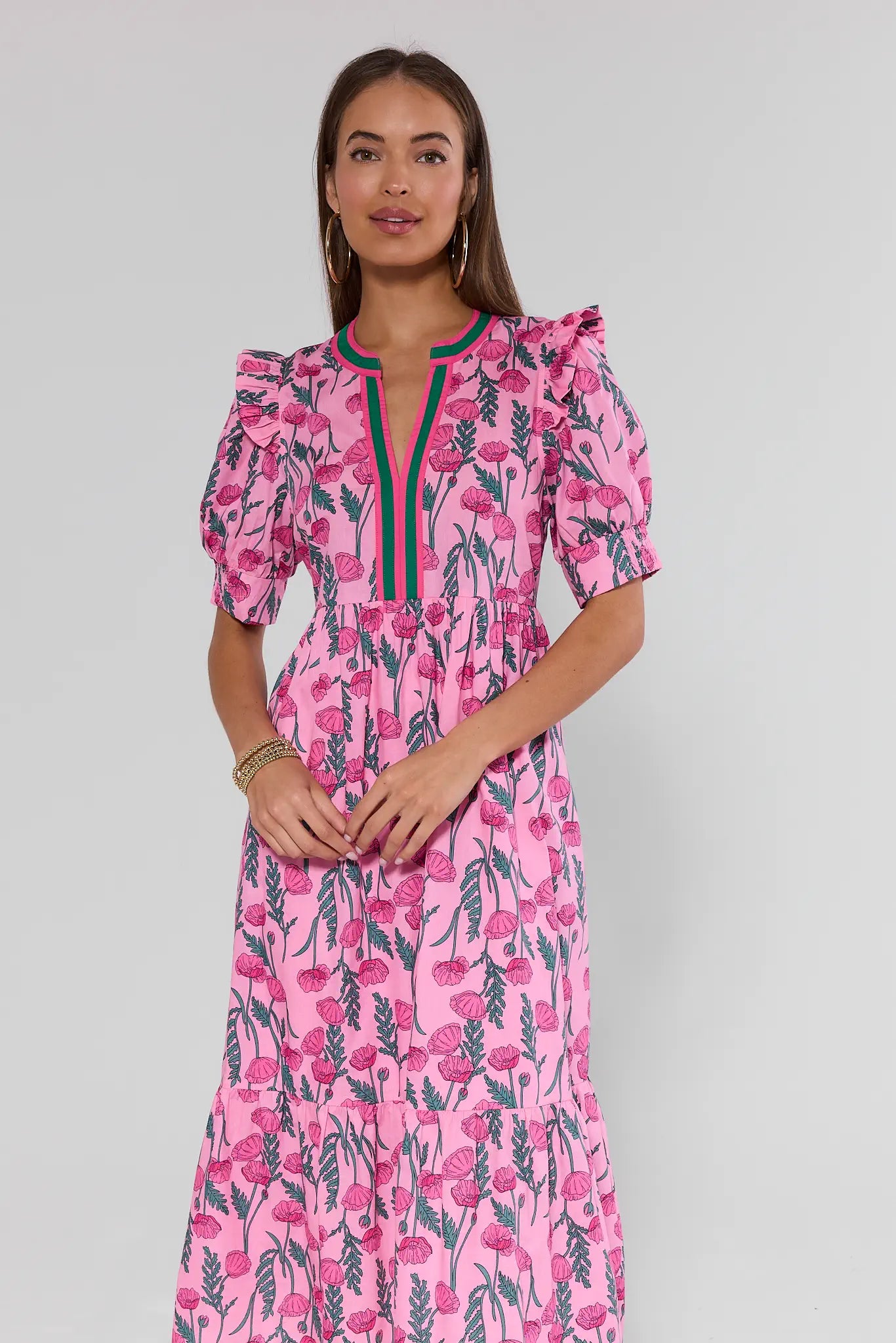 Woman wearing a pink floral dress against a background