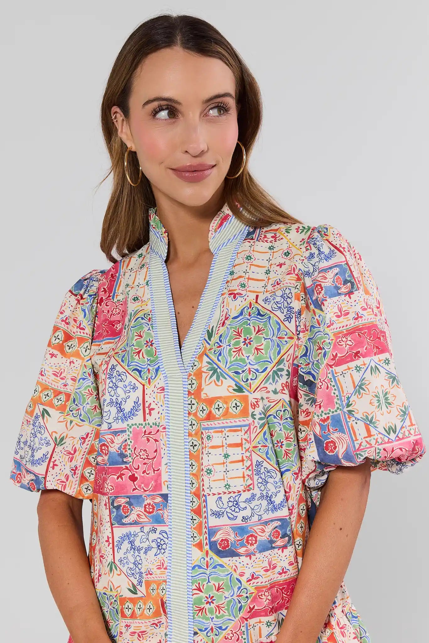 close up Woman wearing a colorful patterned dress on a gray background