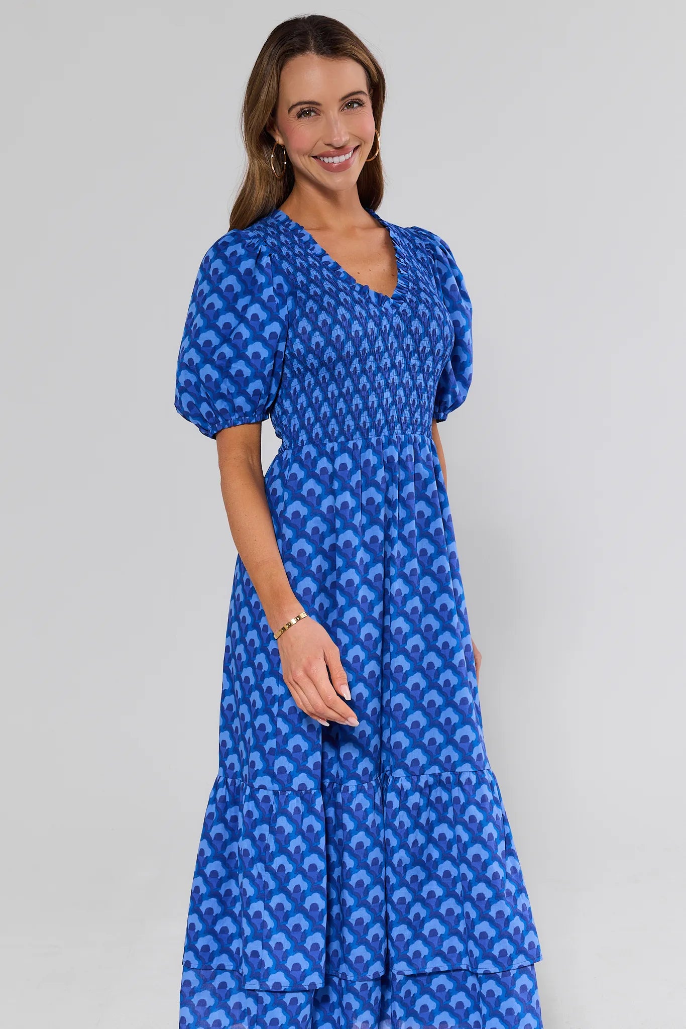 Woman wearing a blue patterned dress on a gray background