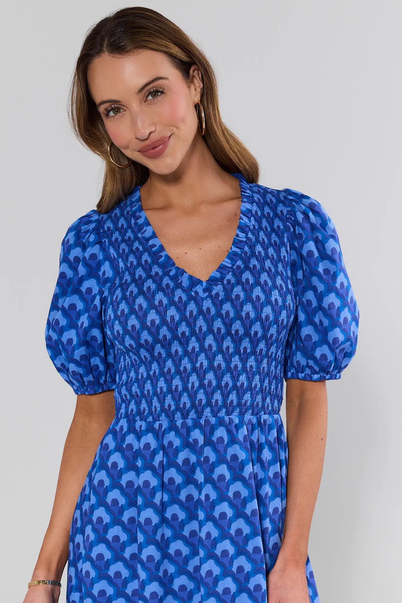 close up Woman wearing a blue patterned dress against a plain background
