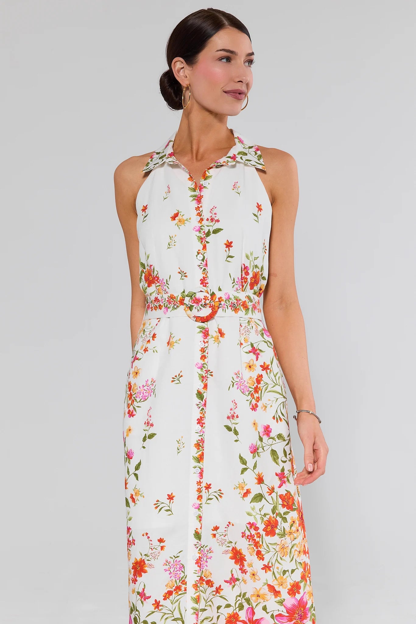 Woman wearing a floral lilith dress on a plain background