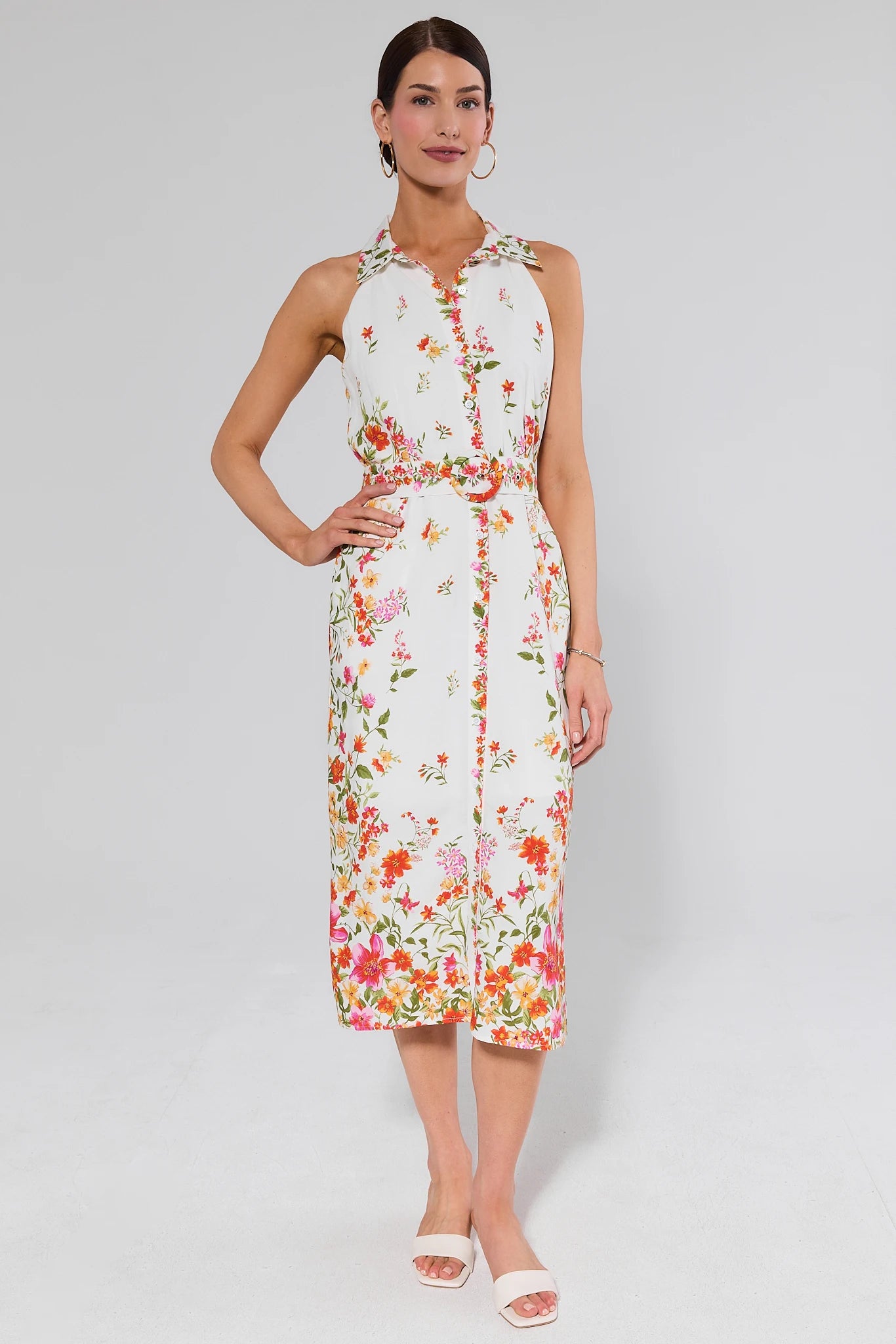 Woman wearing a floral dress and white heels on a white background