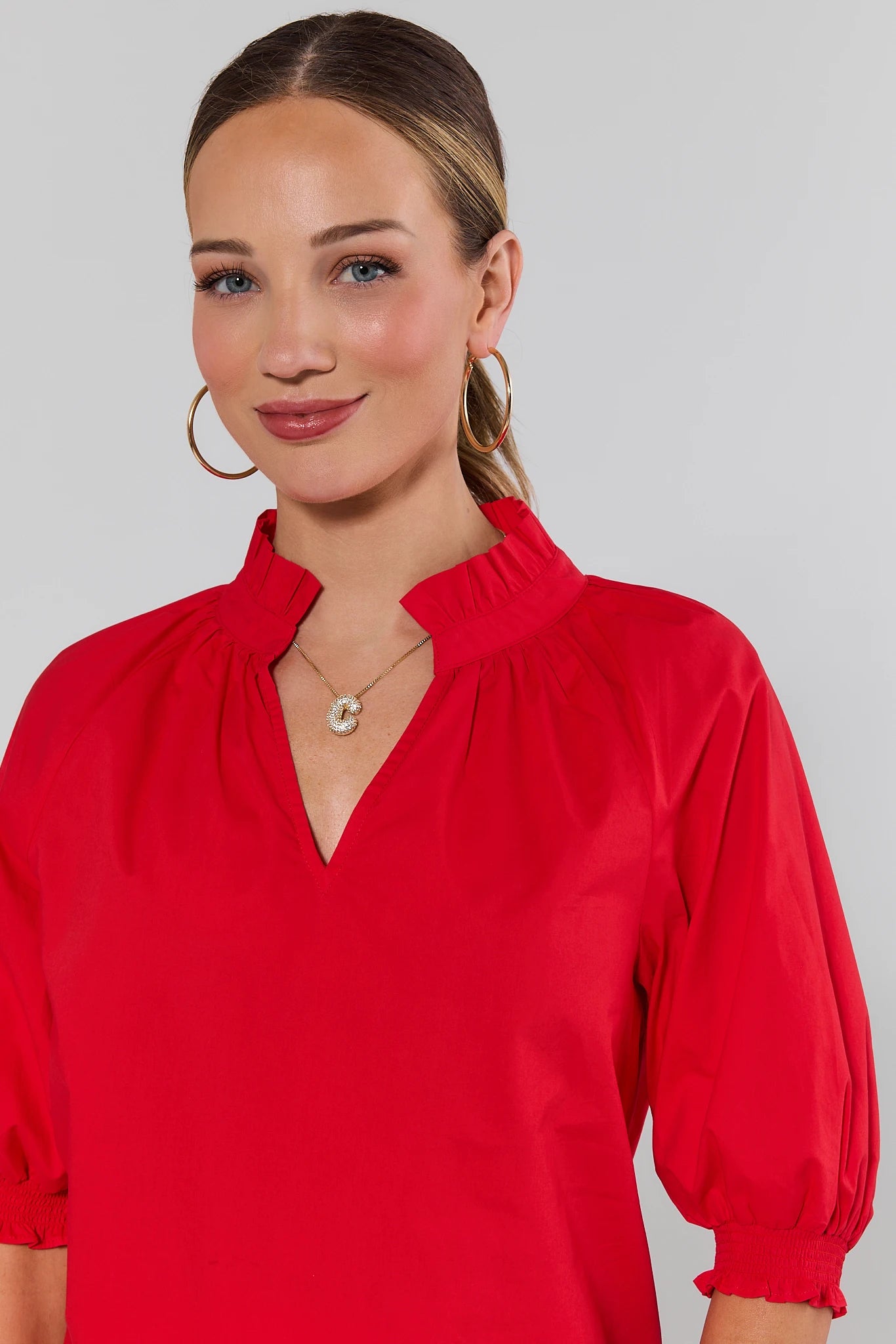 close up Woman wearing a red blouse with a plain background