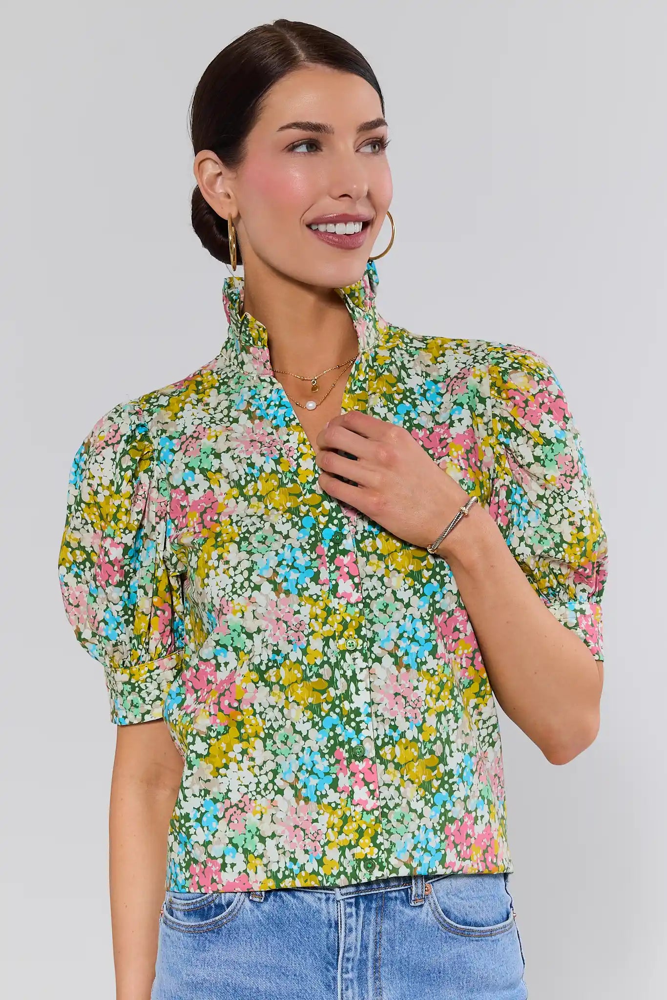 Woman wearing a floral gracie blouse with a plain background